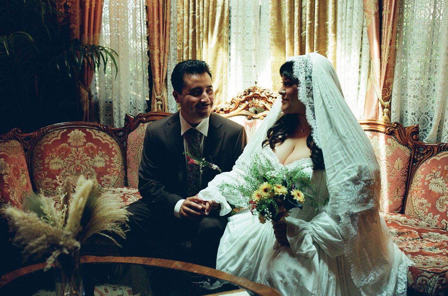 Retro film photo of a couple on a vintage couch in Los Angeles Highland Park