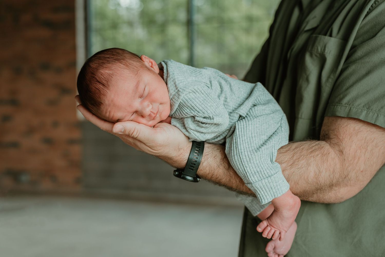 A series of intimate photos showing a baby being held against a brick wall background.