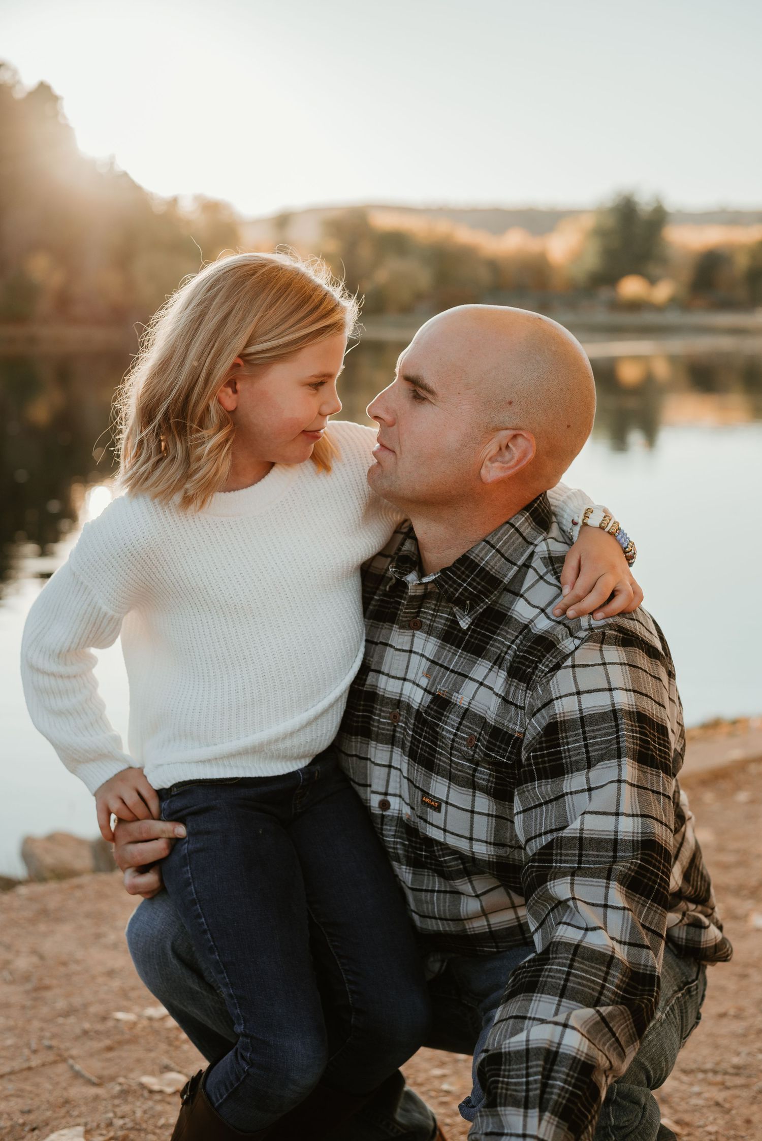 Tender family moment captured by the lake at sunset.