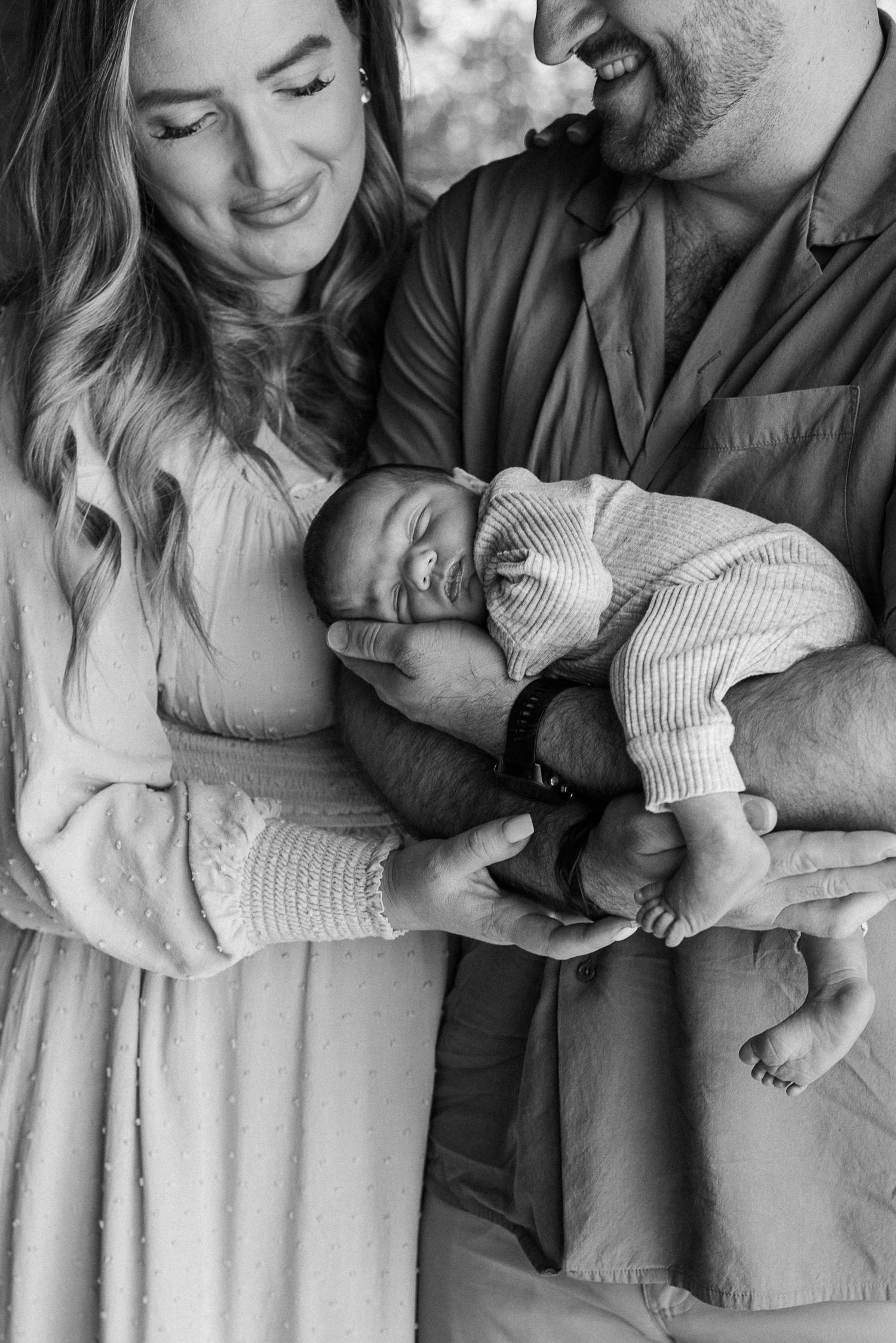 A series of black and white photos showing tender moments with a newborn baby.