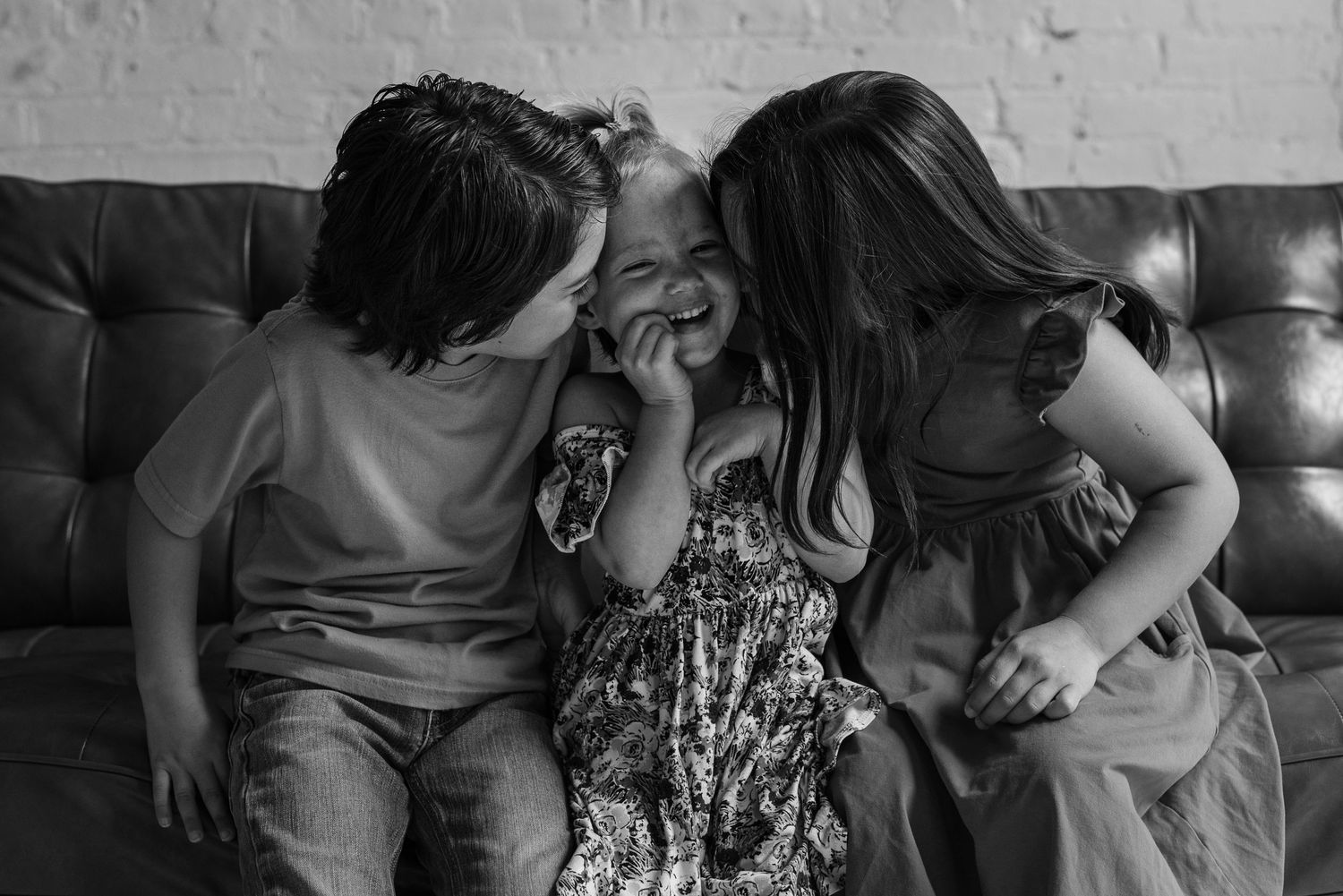 Black and white portrait of family members sharing intimate moments on a couch.