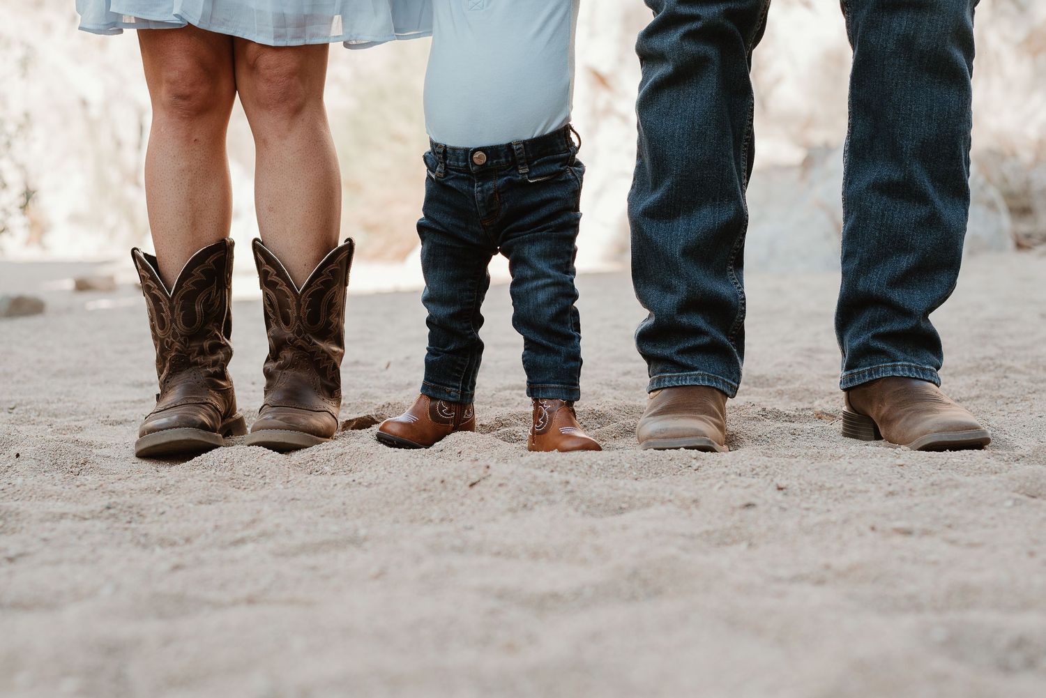 A row of feet and shoes lined up showing different footwear styles from boots to dress shoes on a light surface.