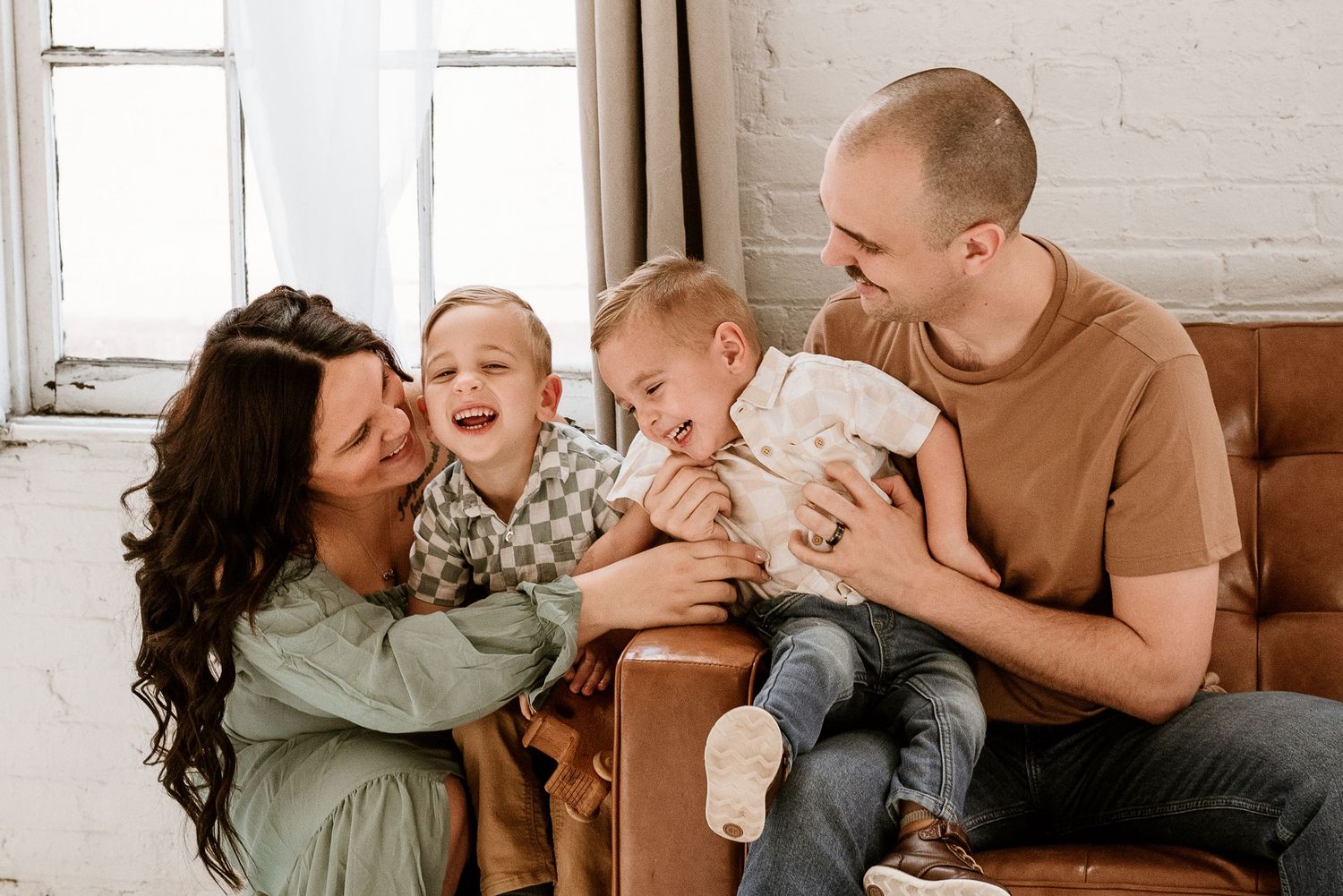 Candid family moments captured on a brown leather couch showing affection and laughter.