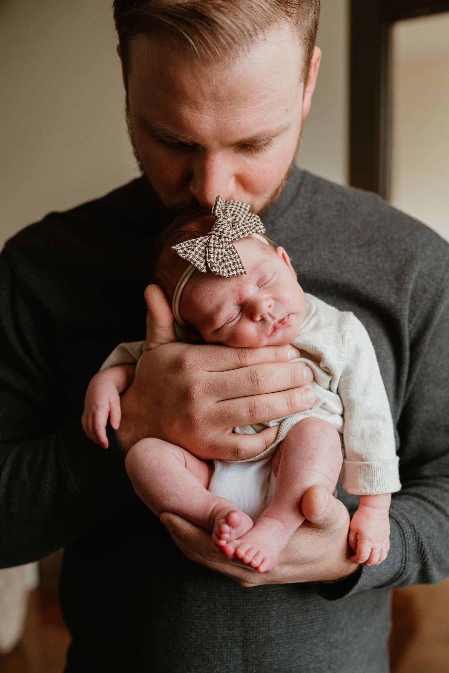 A series of intimate close-up shots showing tender moments between a parent holding and kissing a baby's tiny feet.