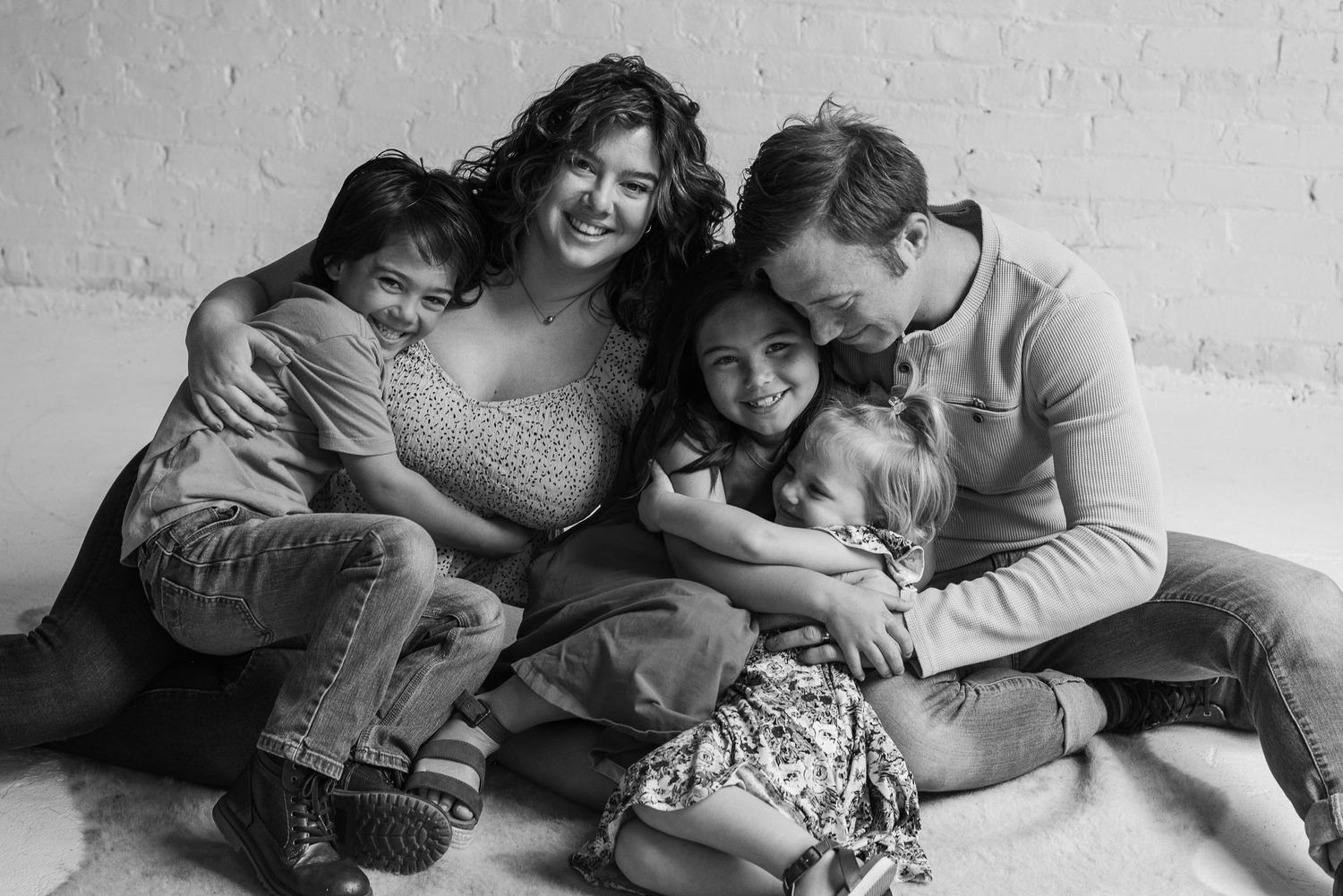 Black and white series of family members lying down and sharing intimate moments together.