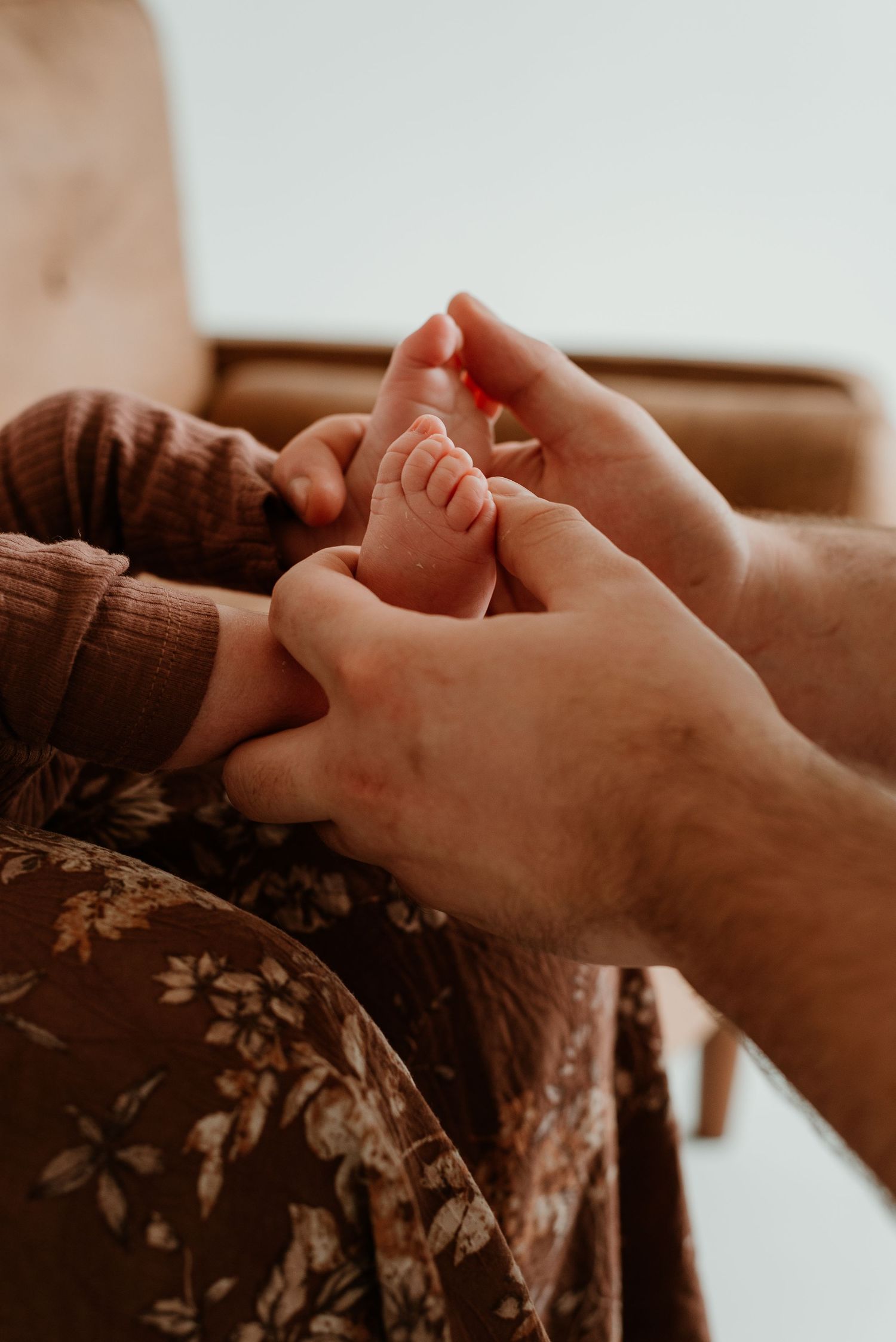 Close-up of hands gently holding and touching each other in a caring gesture against a warm sepia-toned background.