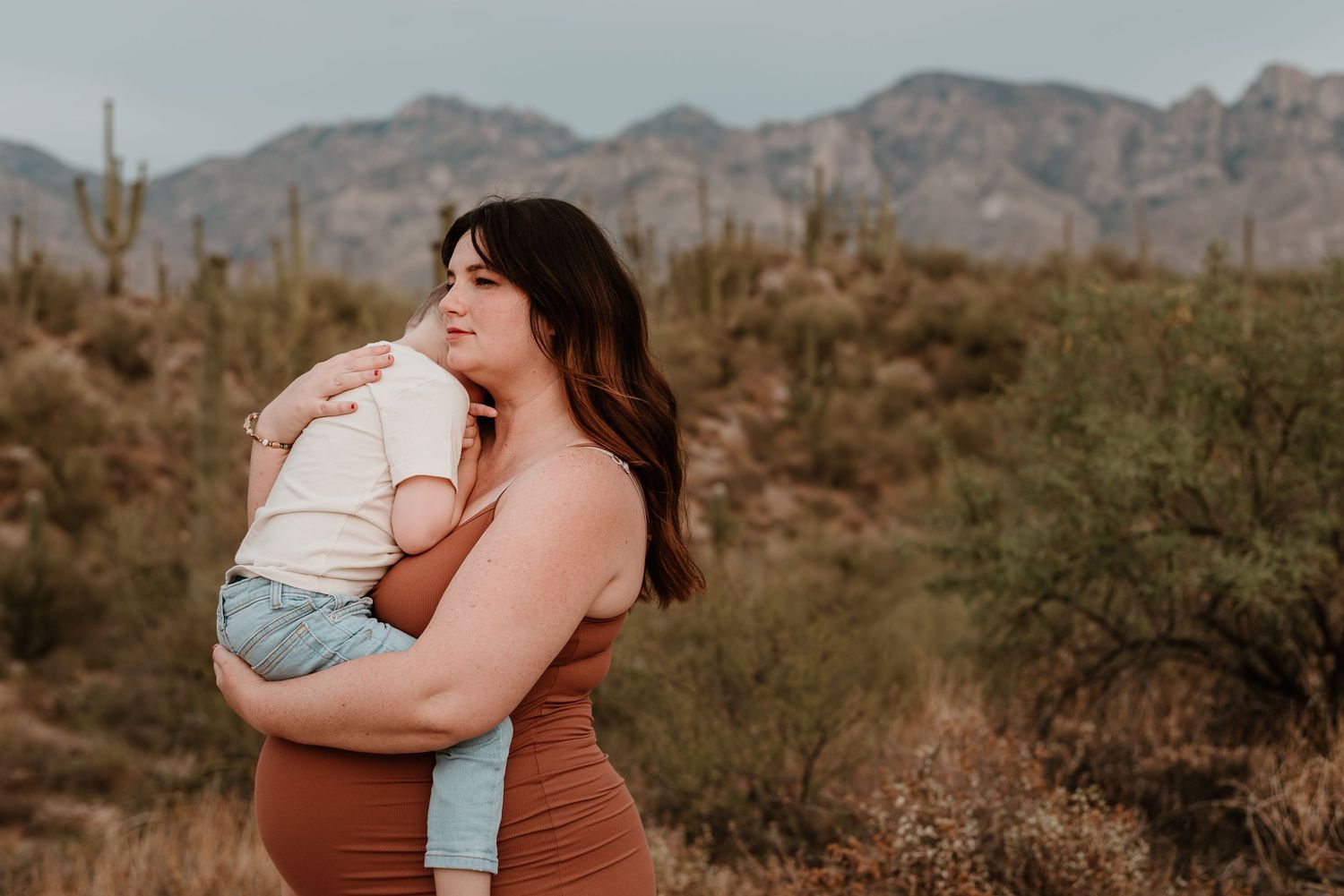 Pregnant mother embraces son