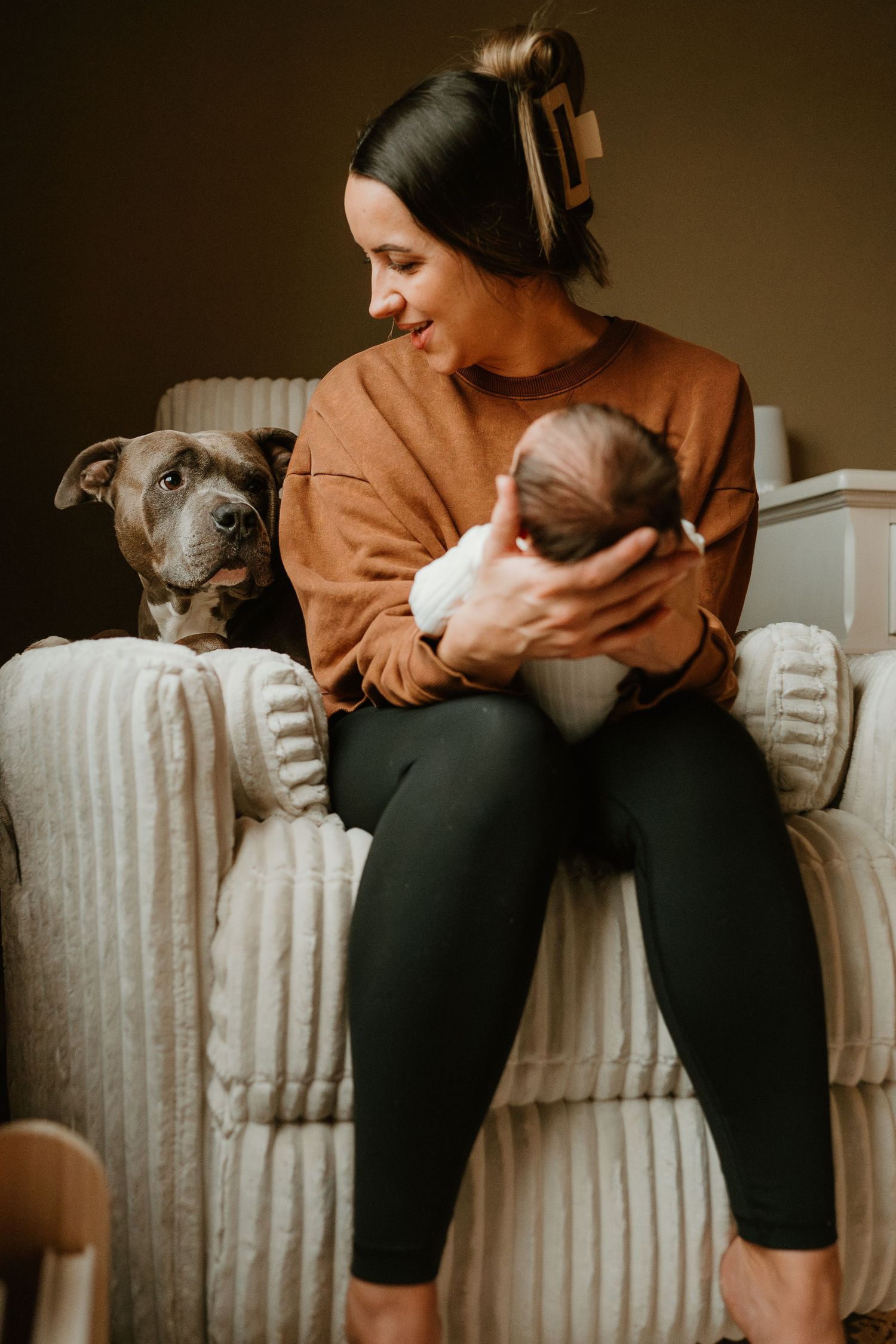 A series of cozy photos showing someone in an orange sweater sitting with their cat on a cream-colored couch.