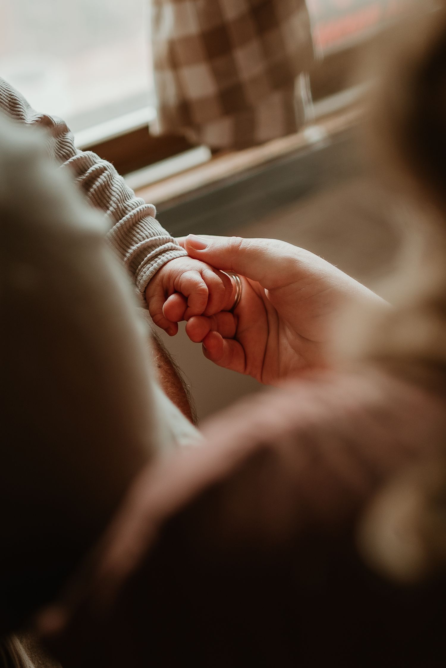 Close-up shot of two hands tenderly reaching toward each other in warm lighting, creating an intimate and emotional moment.