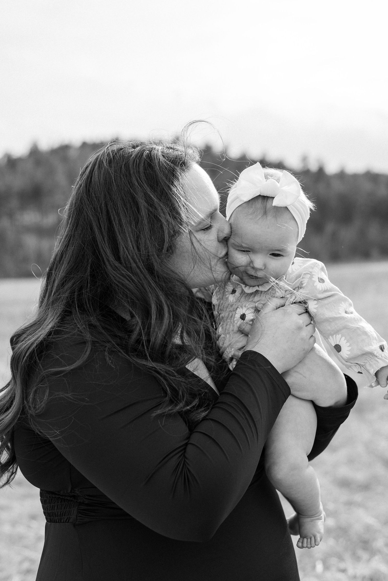 Sweet moments captured between parent and baby in black and white photography.