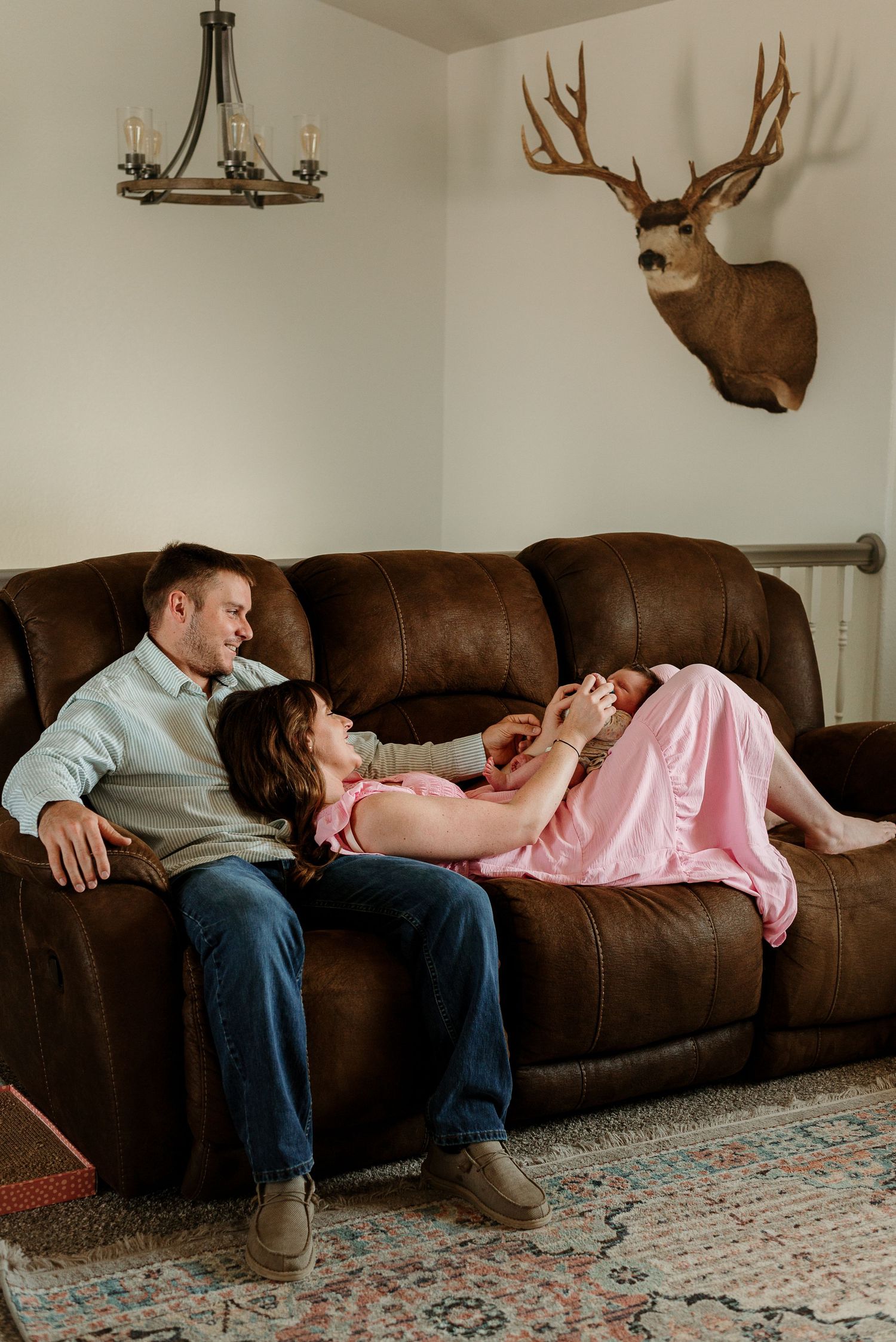 A series of photos showing a couple lounging on a brown leather couch beneath mounted deer antlers on the wall.