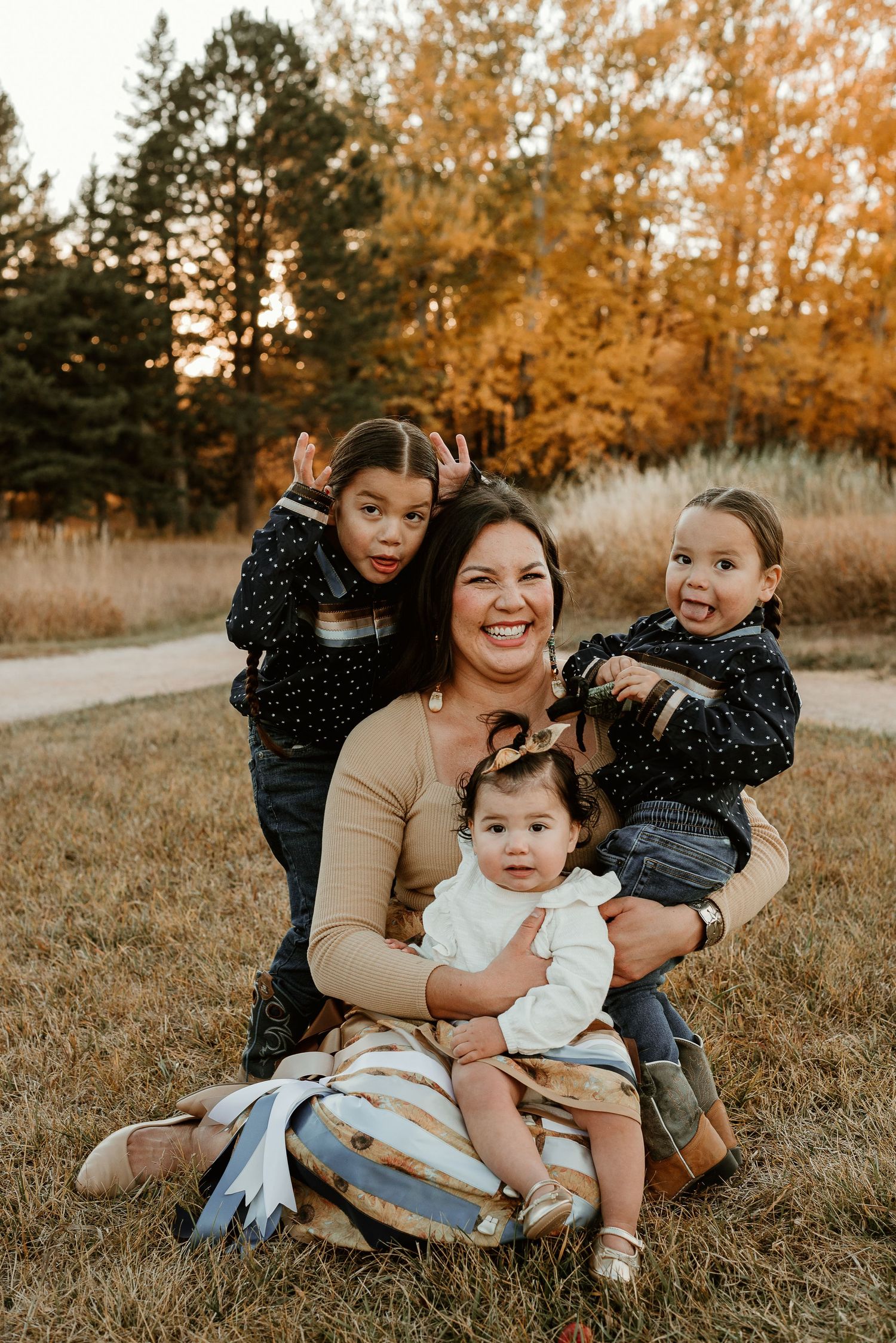 Family group portrait in autumn setting with coordinated outfits and natural golden lighting.