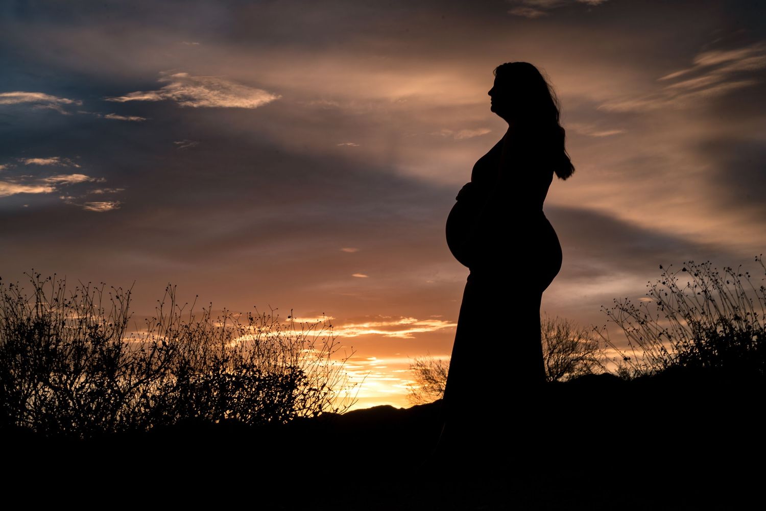 Pregnant woman sunset silhouette