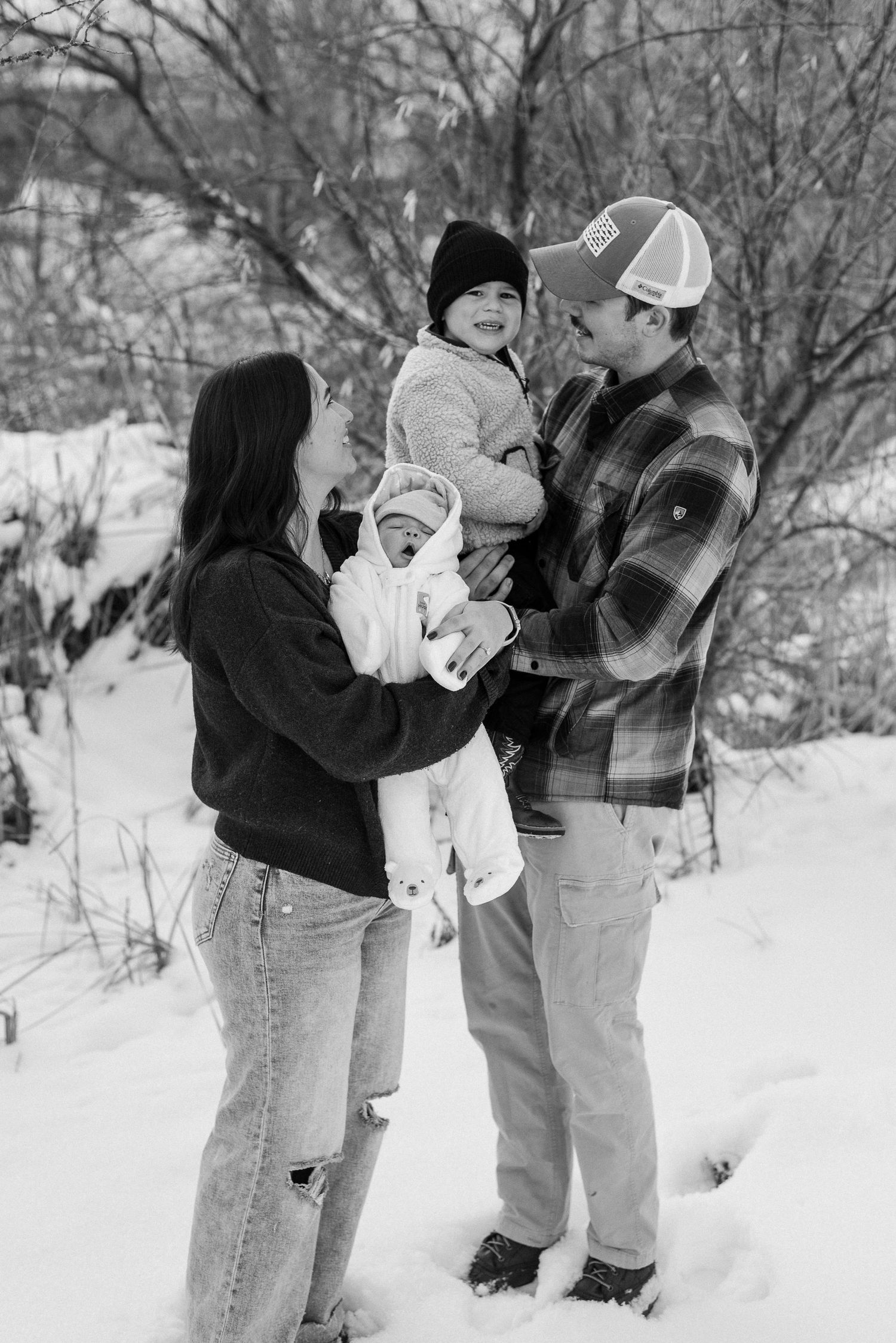 A family enjoys playful moments together in a snow-covered setting.