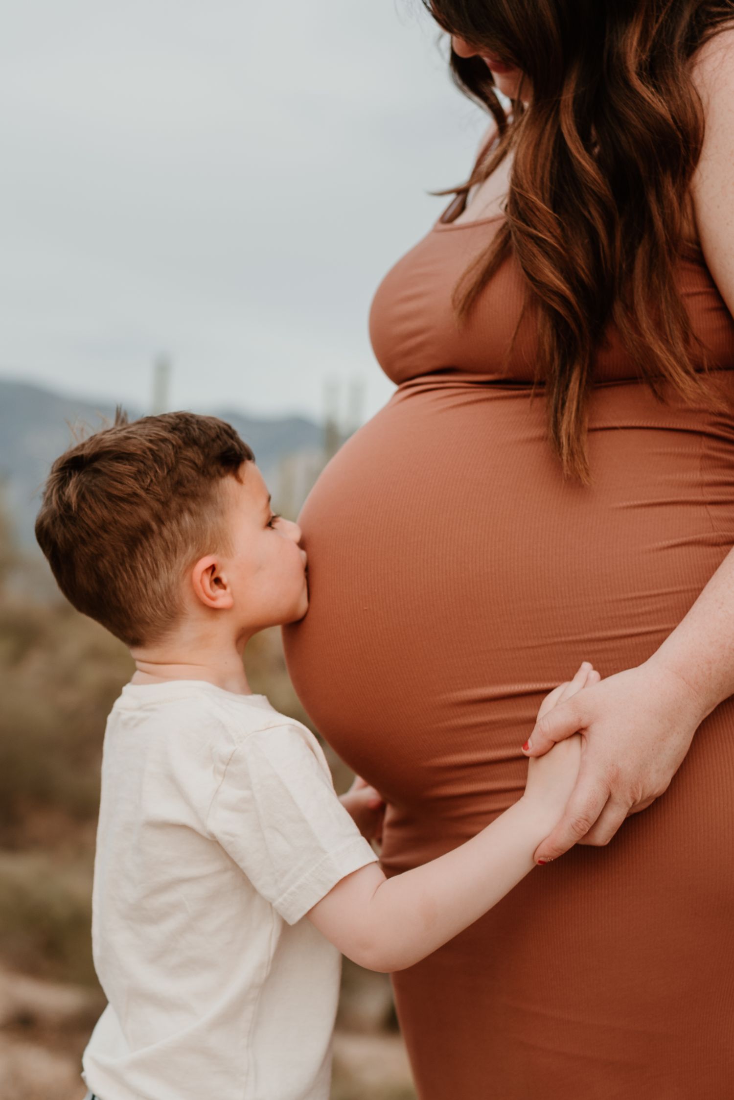 Son kisses mom's pregnant belly