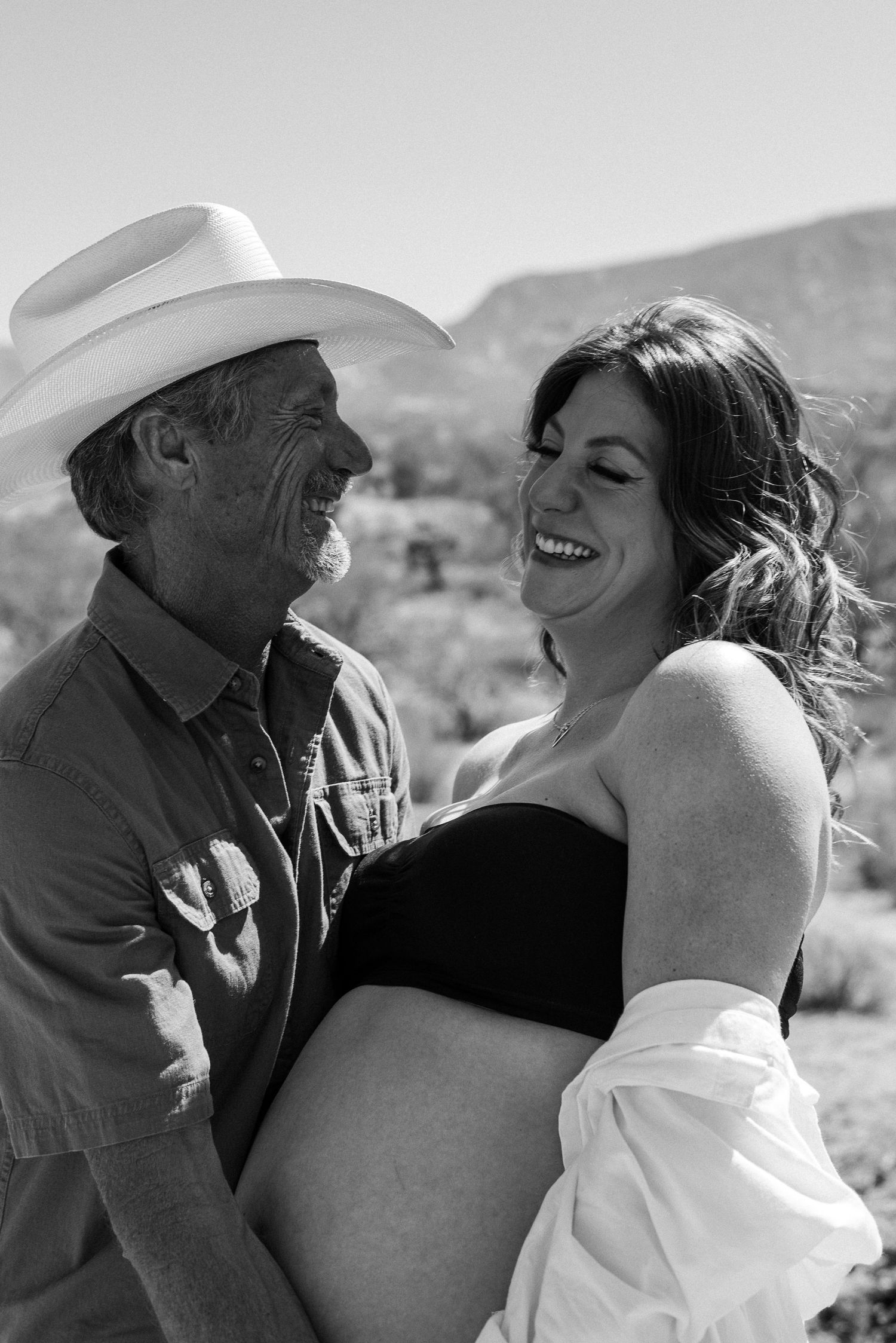 Intimate desert photoshoot with mountains and cacti in the background.