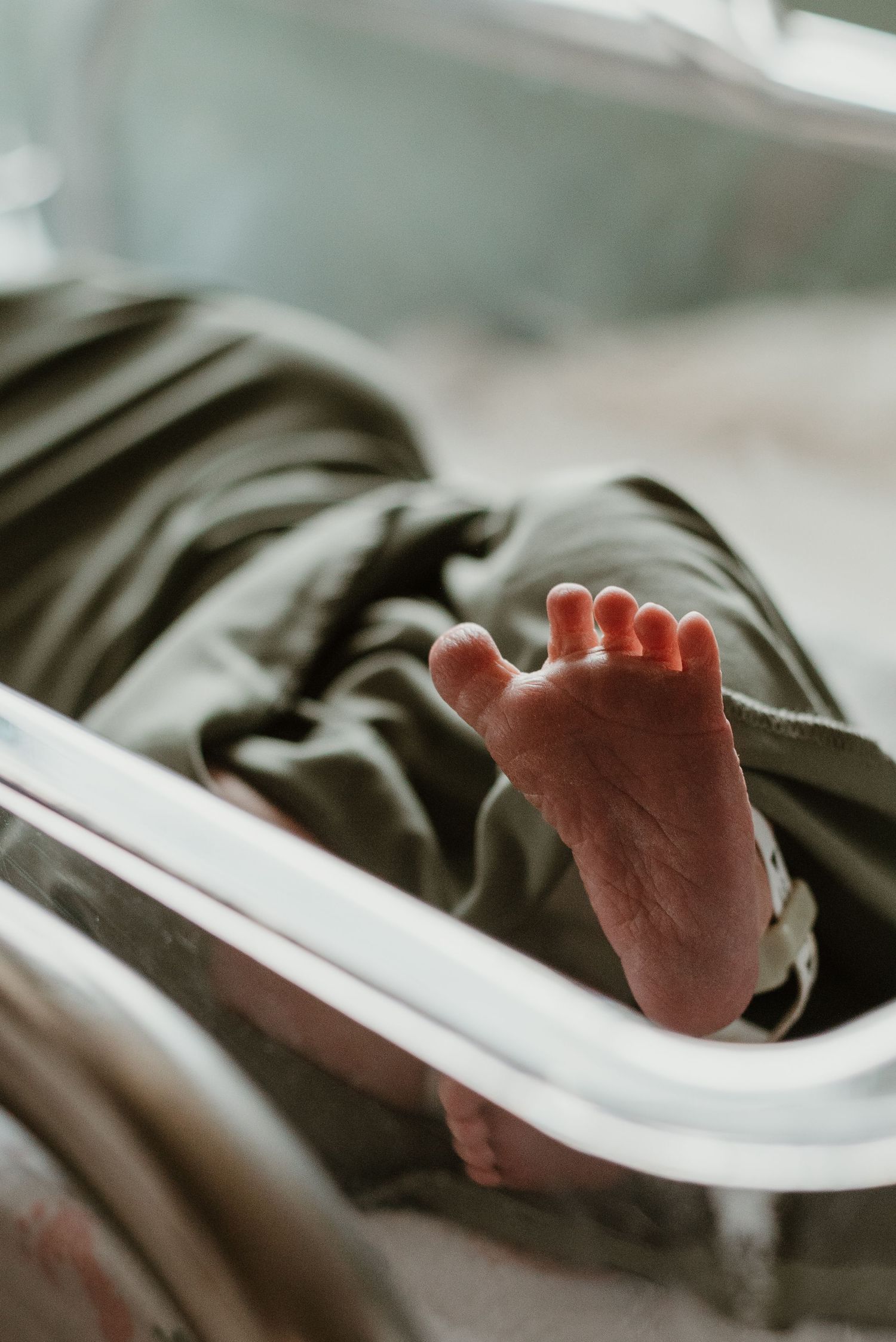 Close-up of tiny baby feet against white blankets.