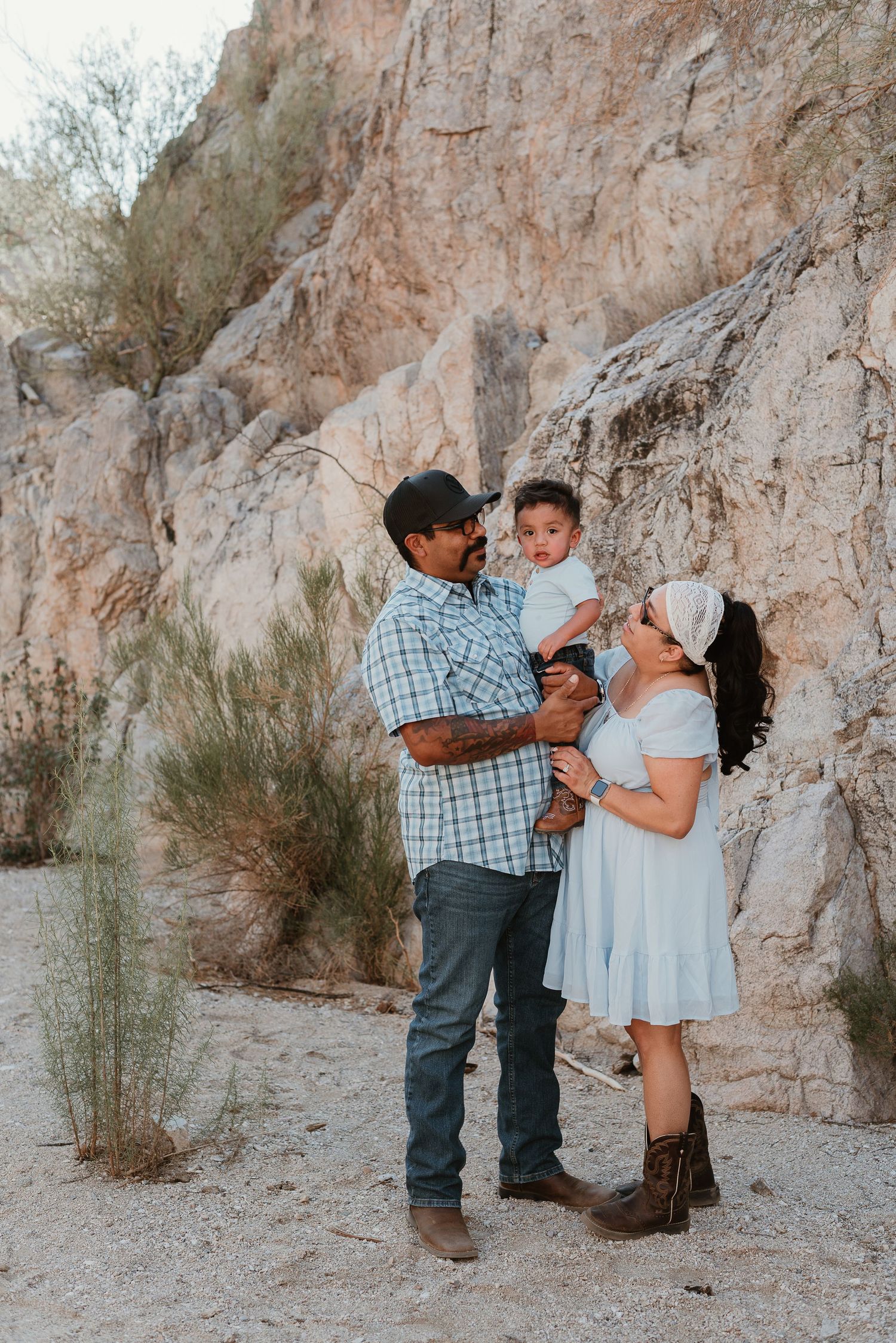 A family shares a tender moment together against a rocky desert cliff backdrop.