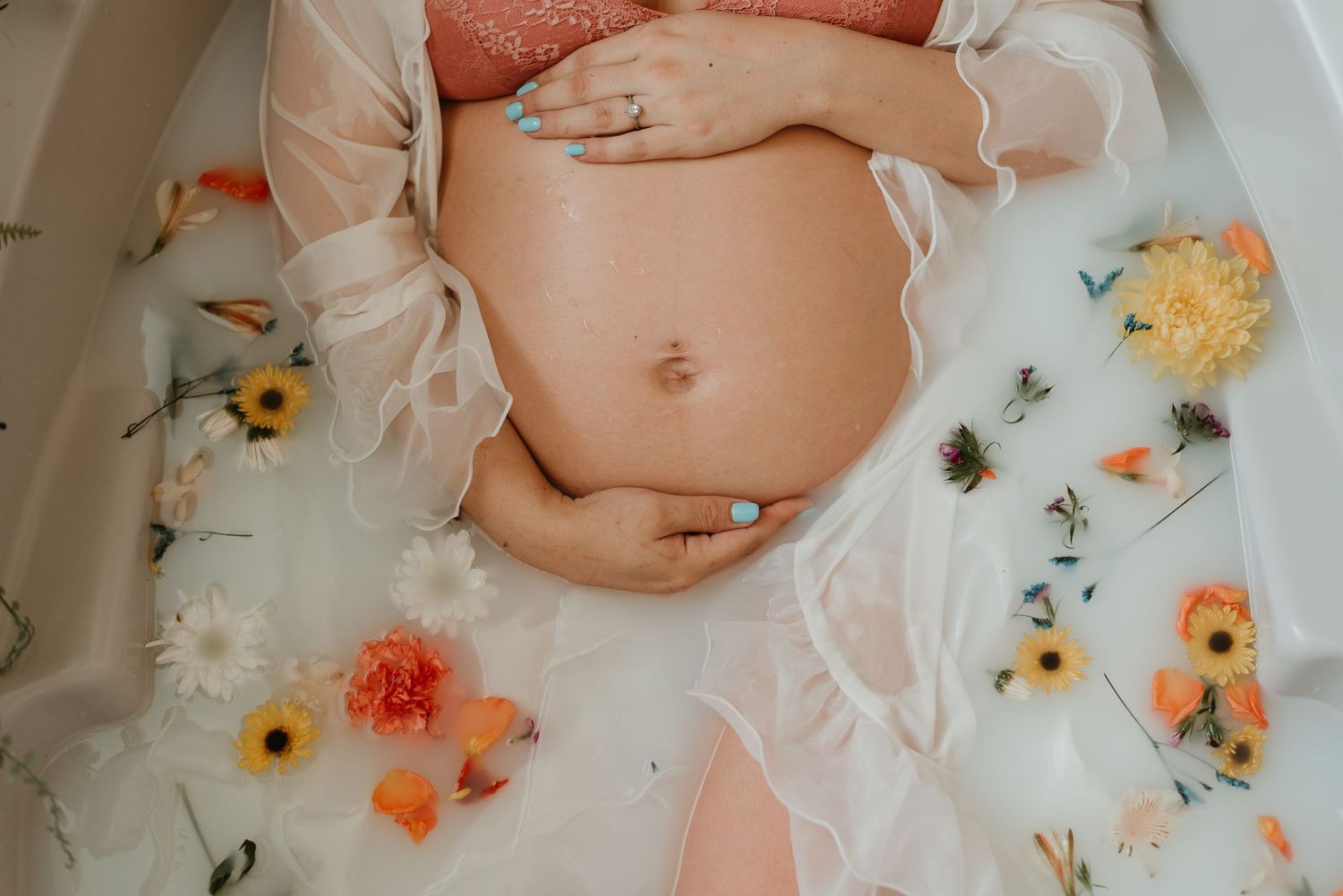 Artistic milk bath photography with floating flowers and delicate lighting.