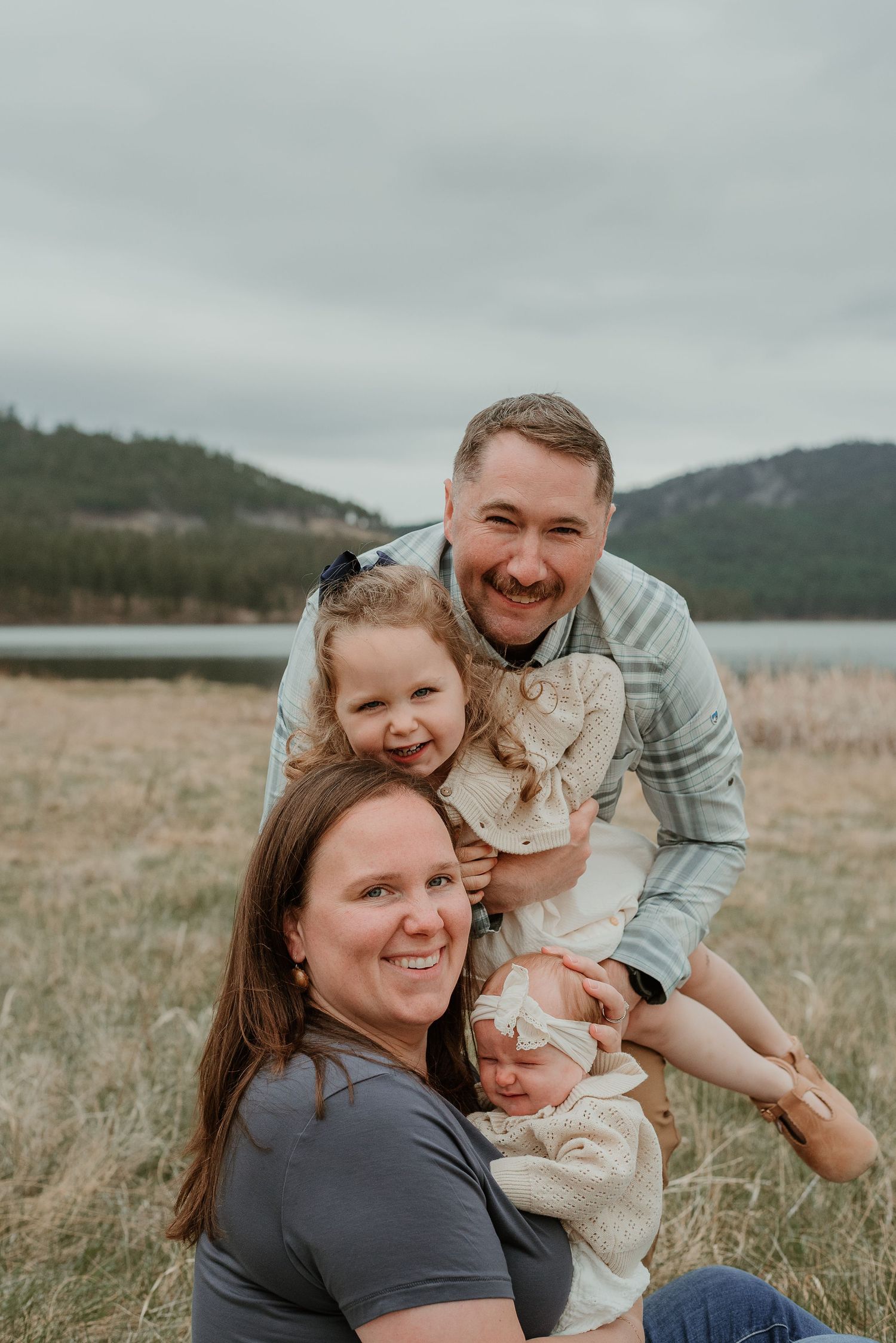 Candid family portrait showing joyful interactions in an outdoor field setting.