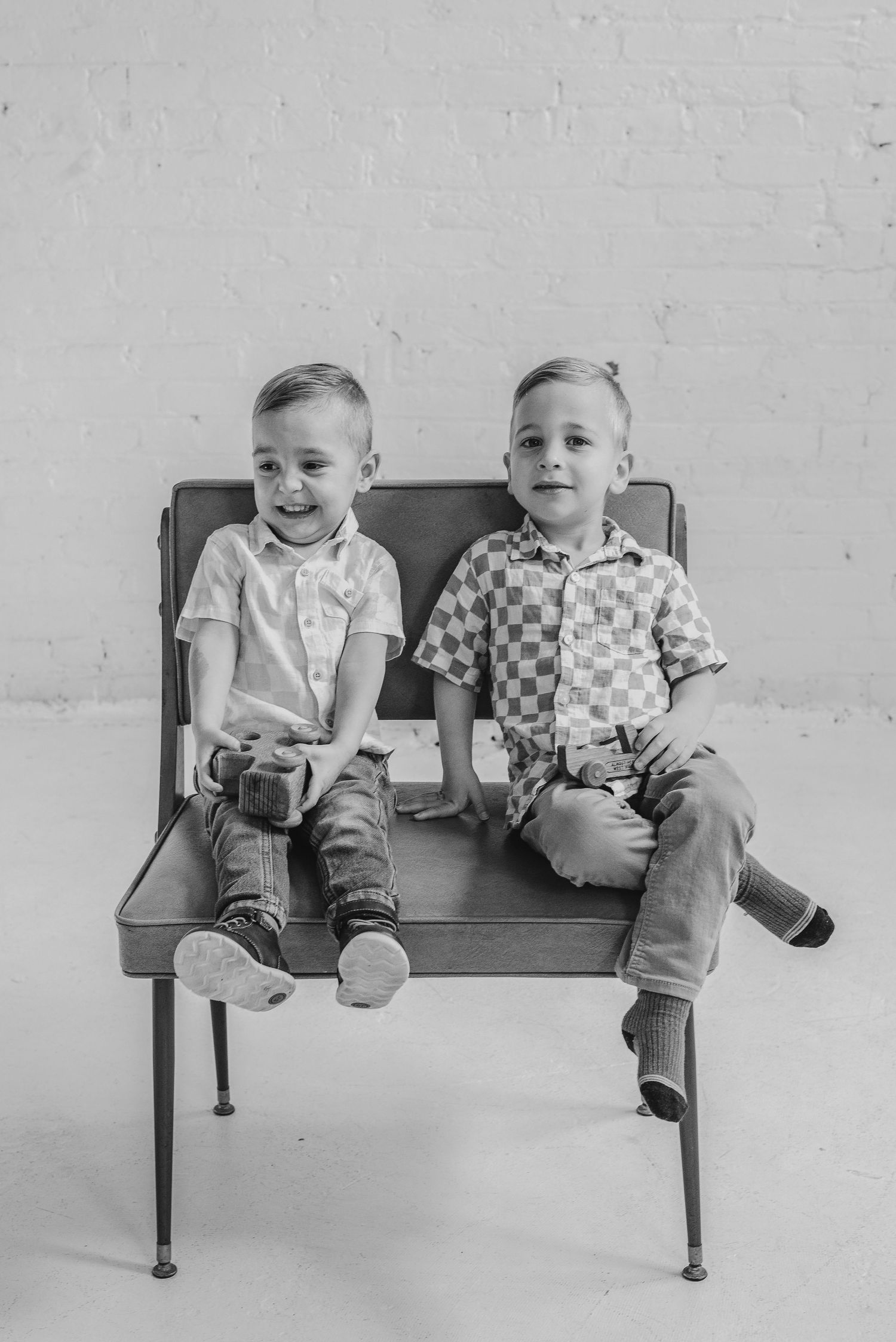 Two brothers sit on a bench