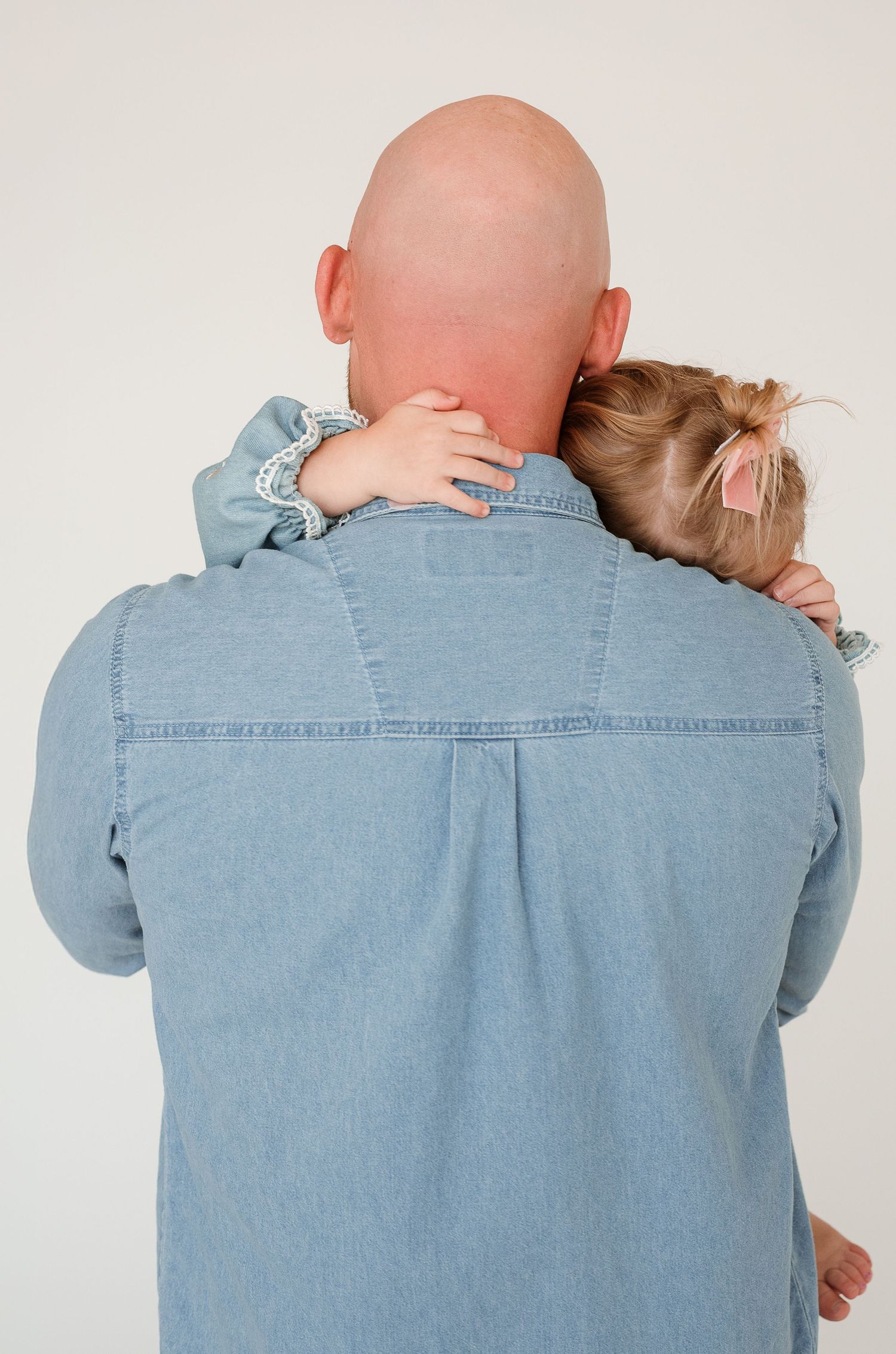 A person in a denim shirt is shown from behind with their head tilted in five sequential poses.