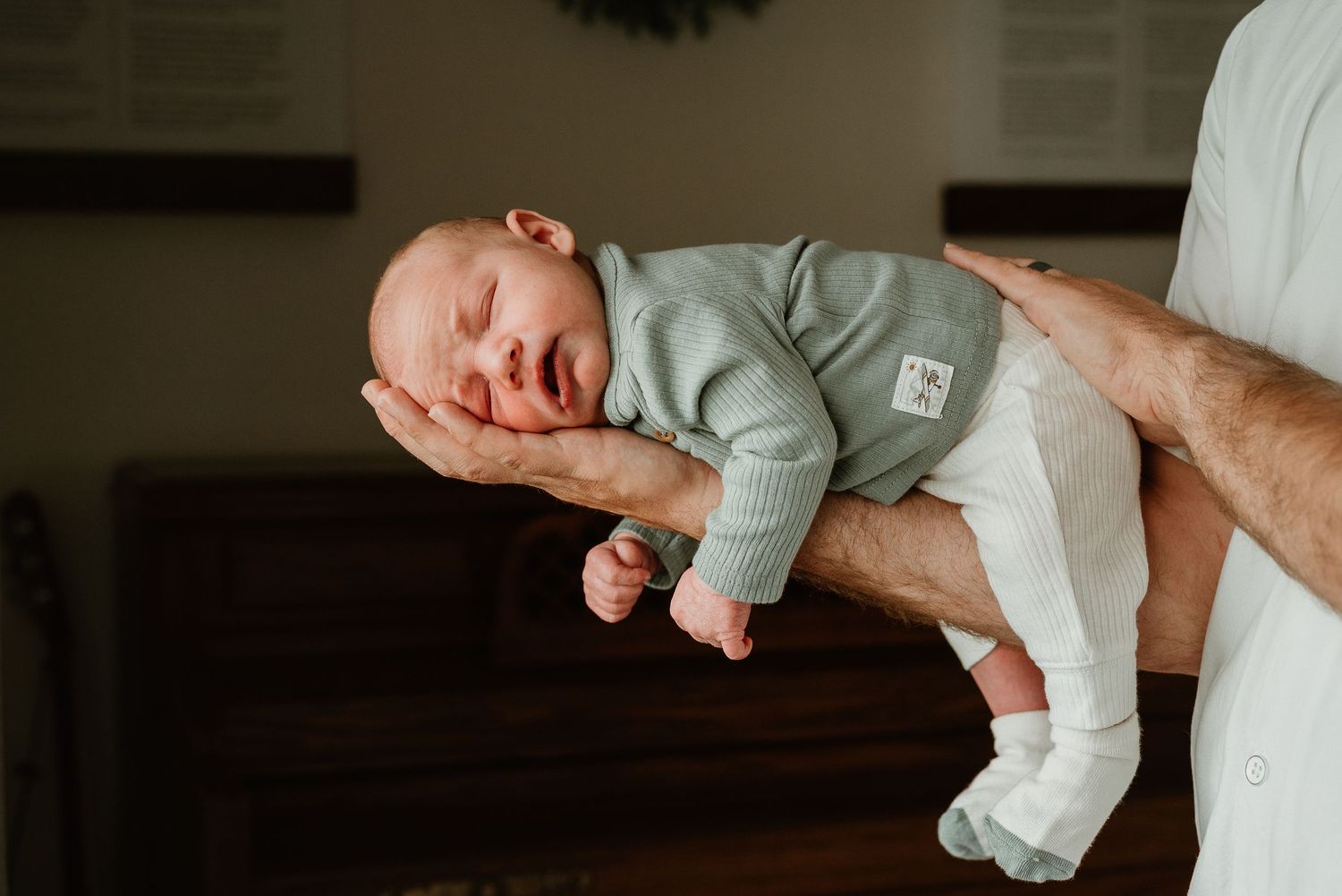 Parents holding and admiring their newborn baby in a series of intimate shots.