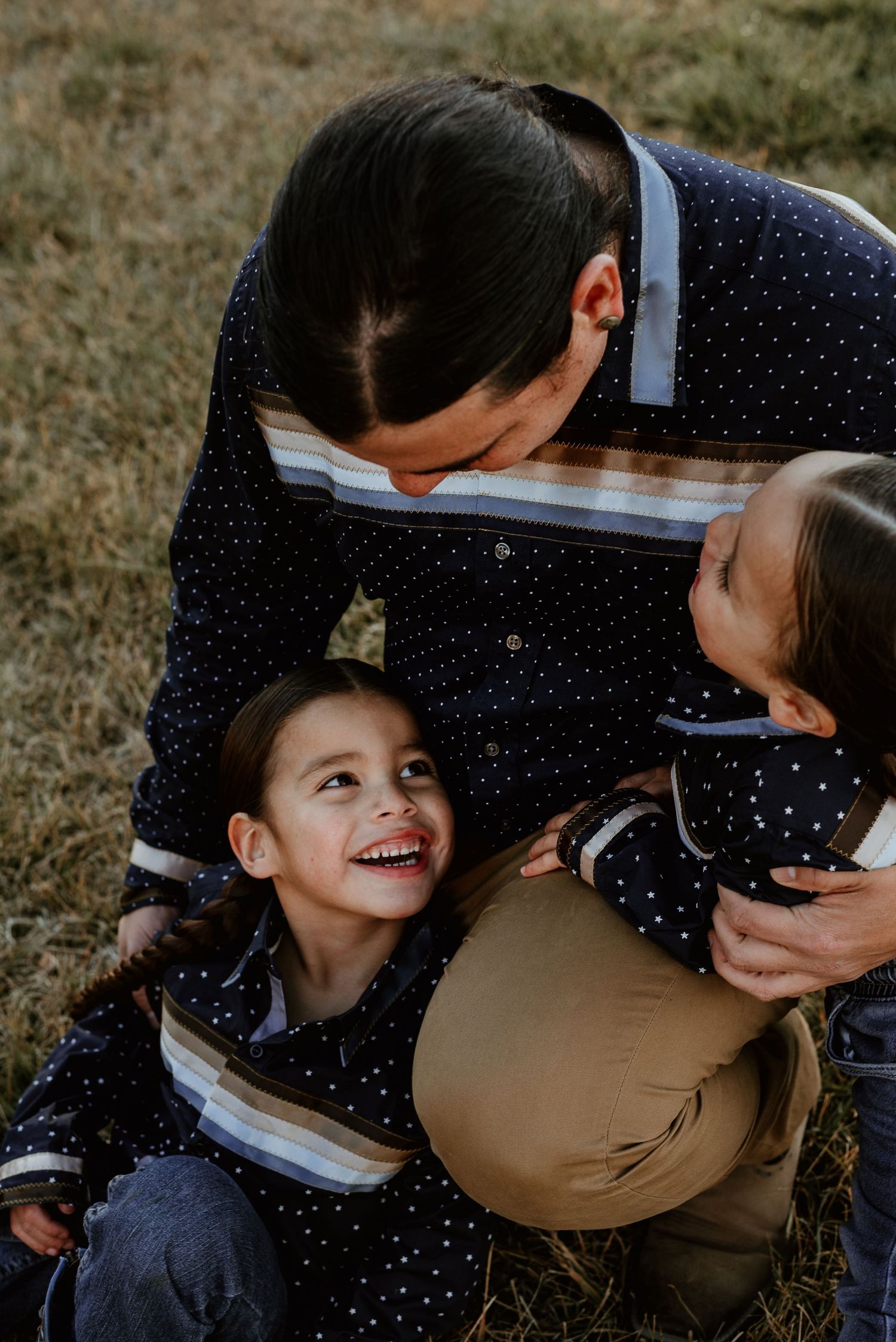 Intimate family interaction captured in close-up during outdoor photo session.