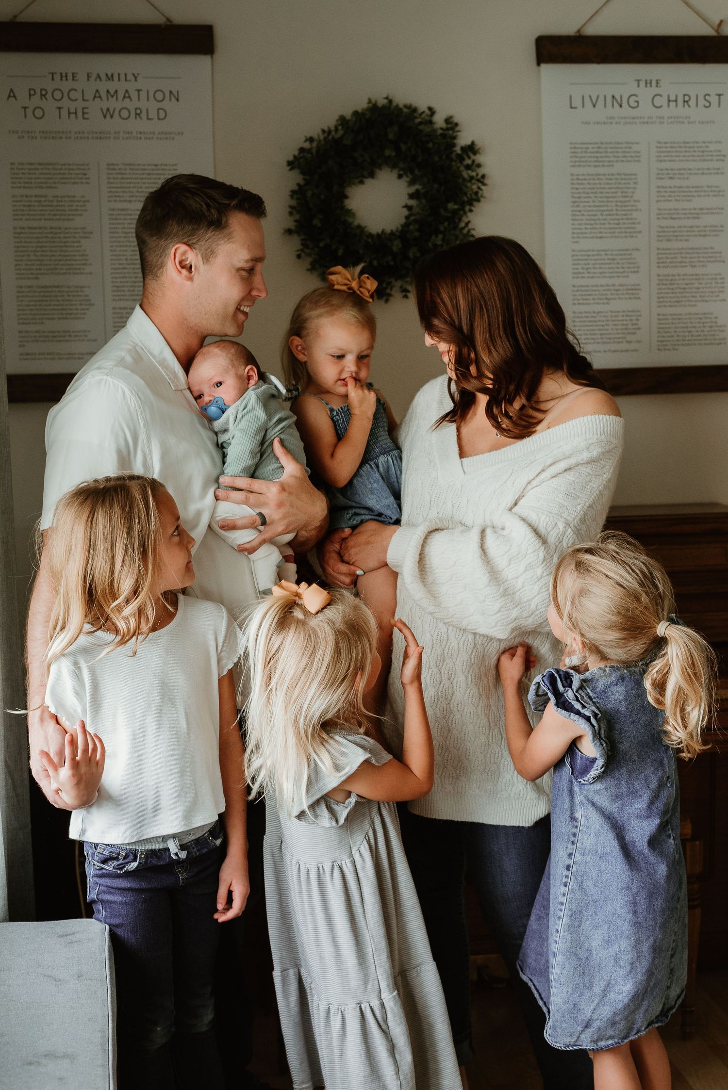 Family portrait sequence showing multiple people in coordinated white and neutral outfits against a wall with text.