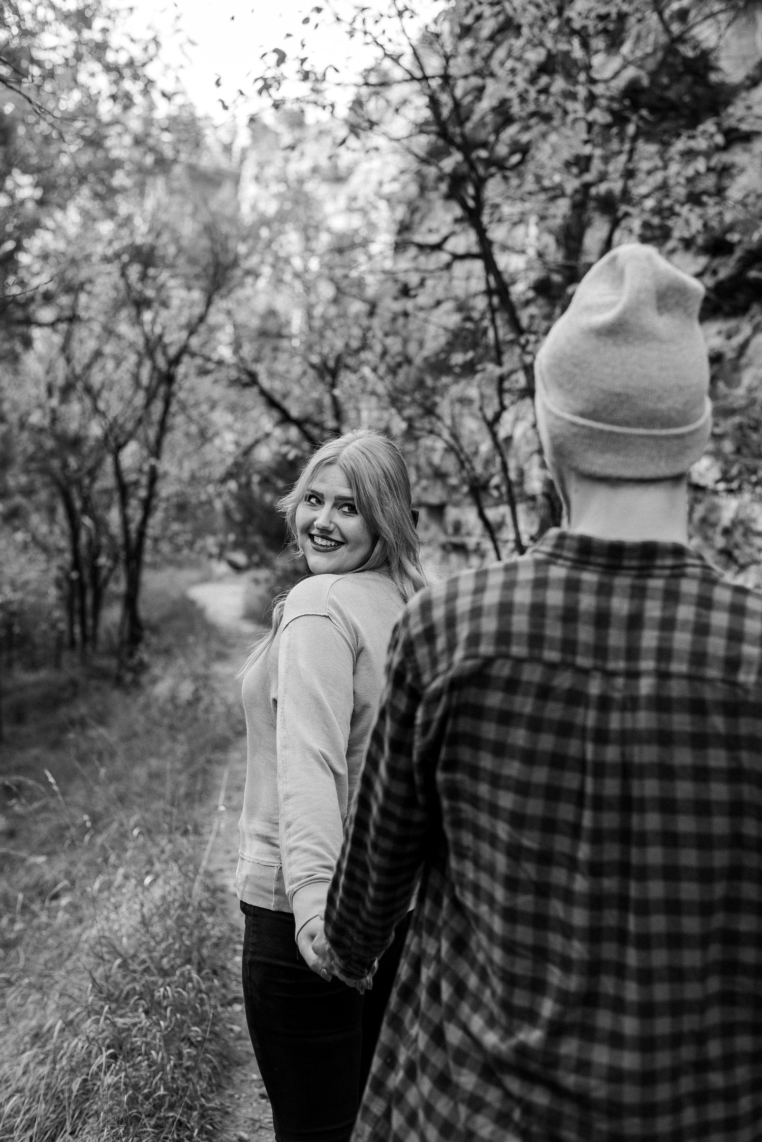 Black and white photos capture intimate moments between a couple in a natural outdoor setting.