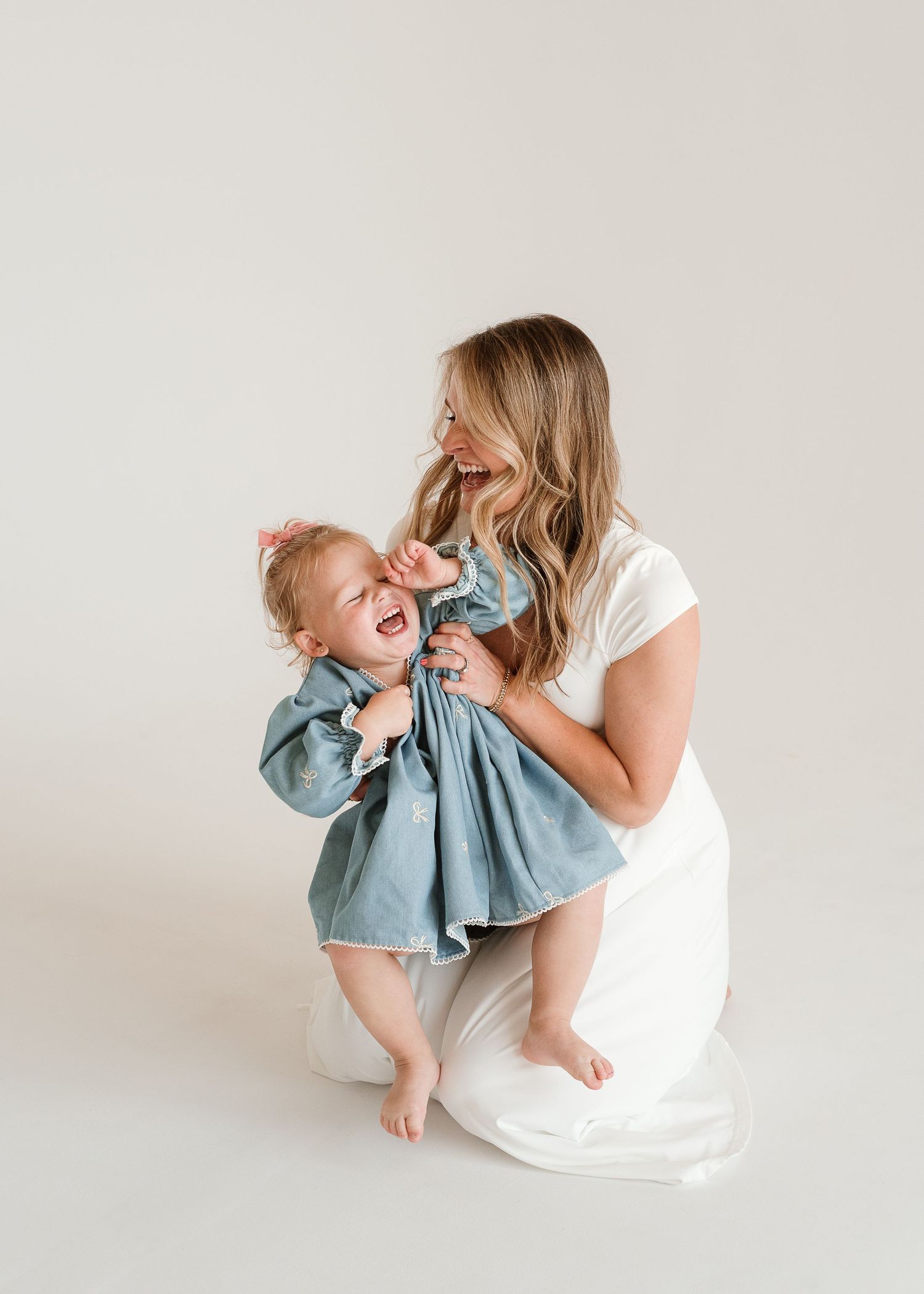 A parent and baby share joyful moments together in a series of candid photos against a light background.