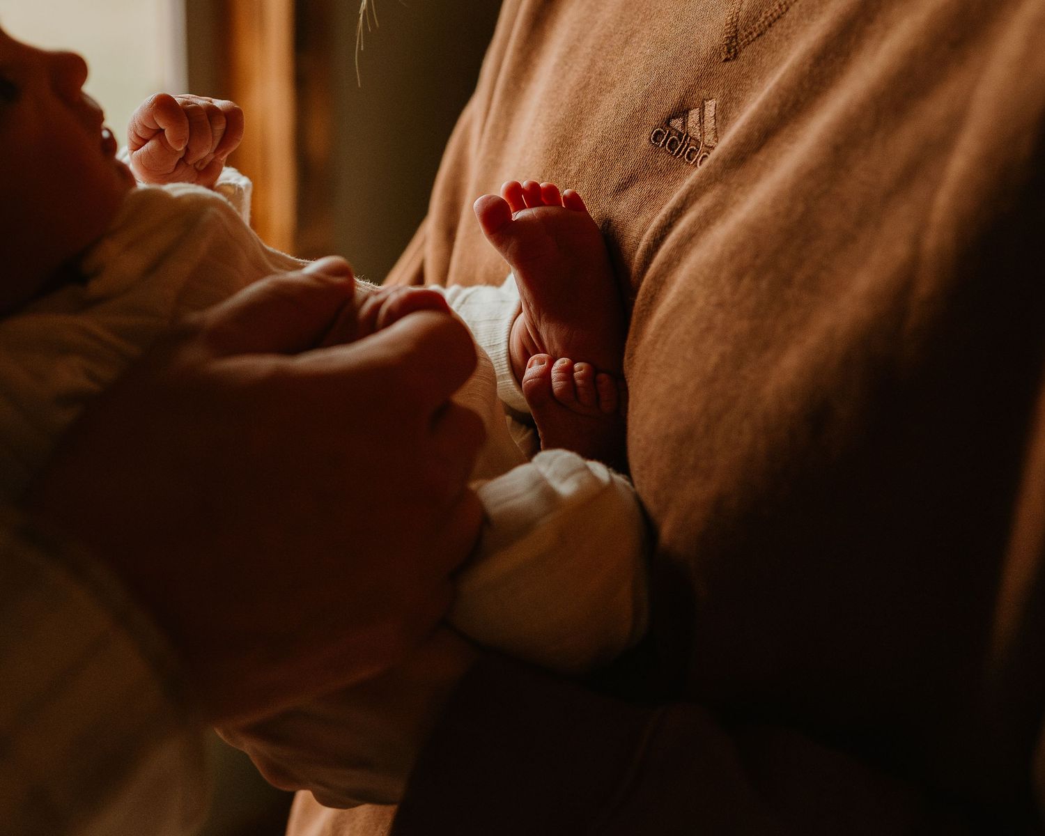 Warm-toned artistic photo of baby details in soft natural lighting.