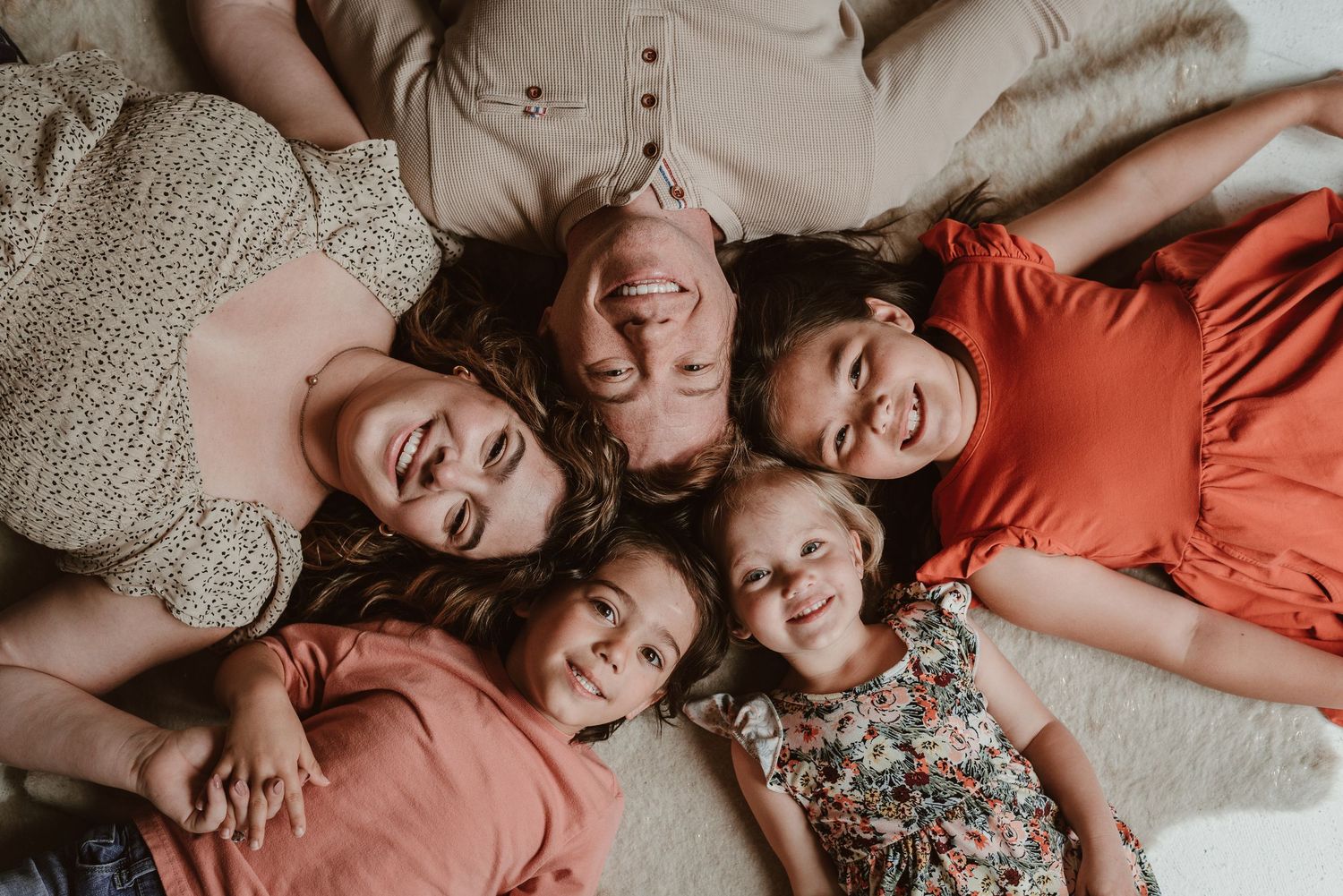 Candid family photos showing warm embraces and laughter in coral and neutral tones.