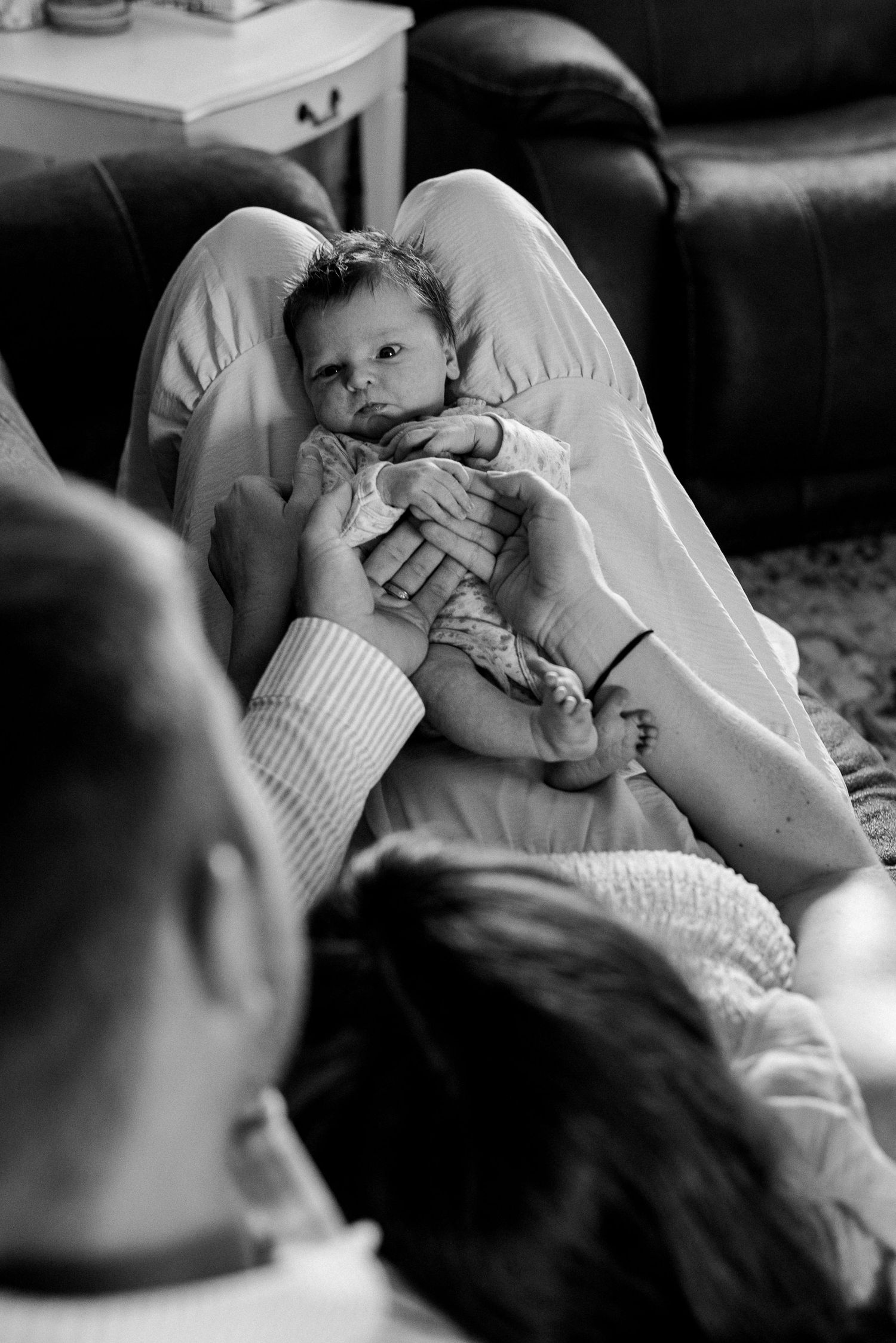 A series of black and white photographs showing a baby being held and comforted in someone's arms.