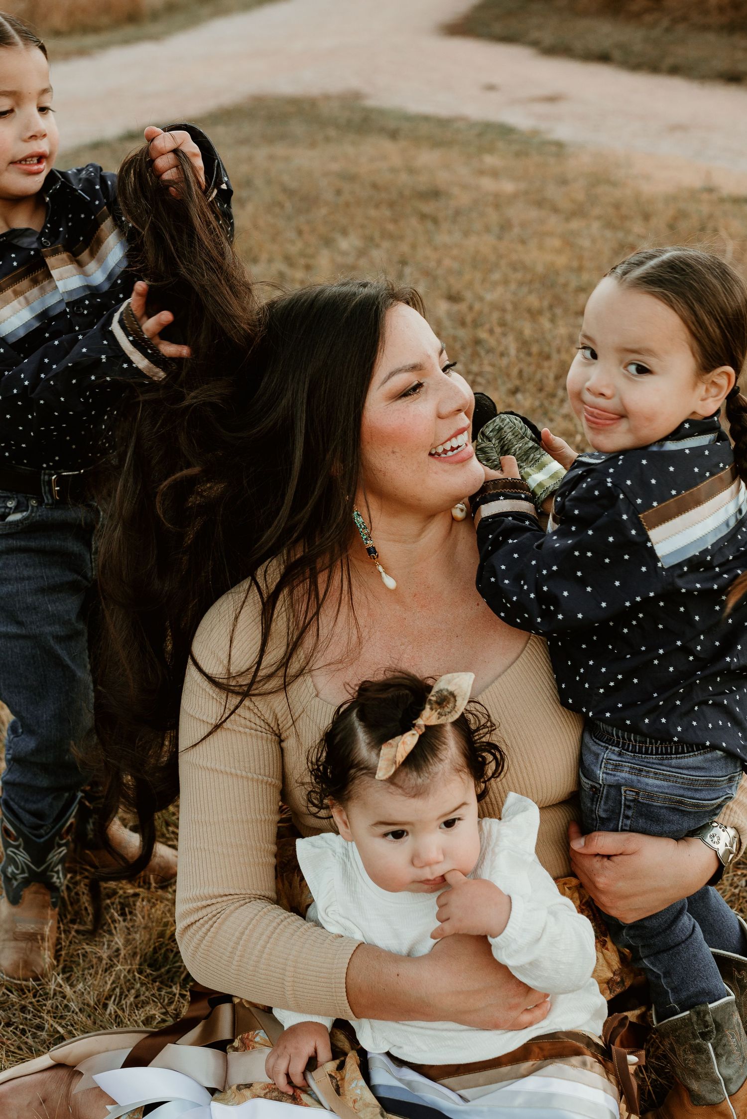 Candid family portrait showing playful interaction outdoors during sunset.