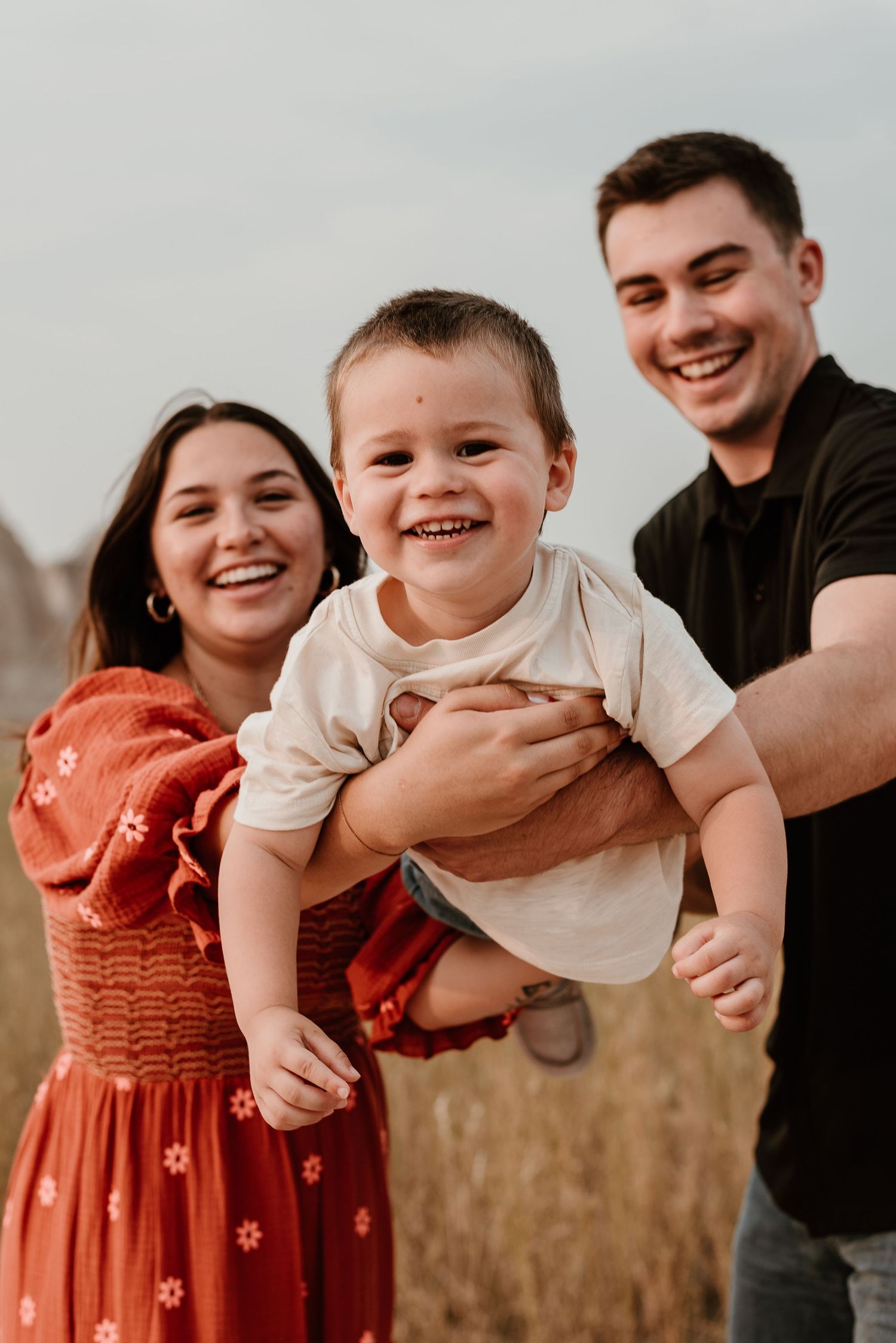 Joyful family moment captured against natural desert landscape backdrop.