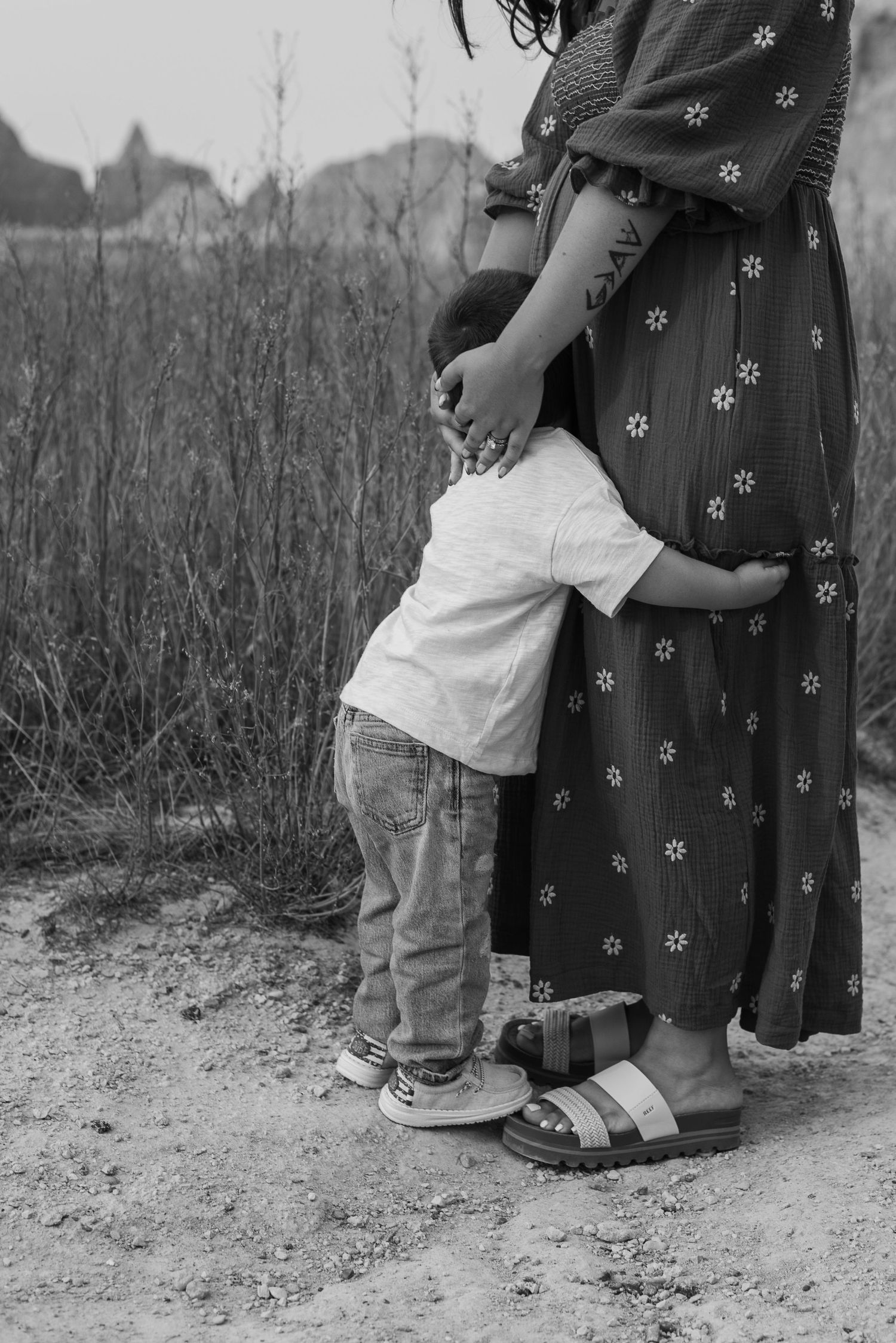 Black and white photo series showing close-up shots of a small child hugging someone's legs.
