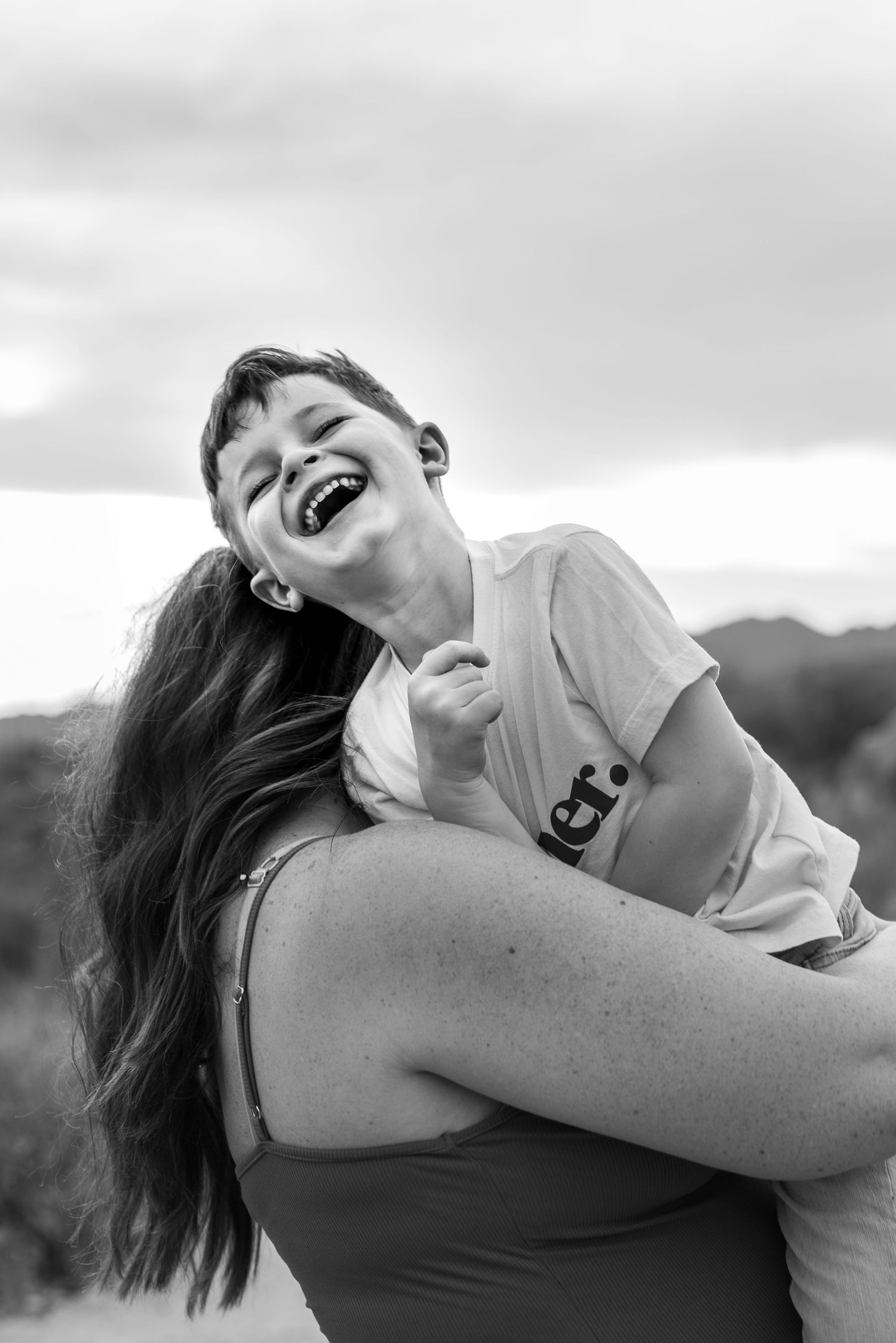 Black and white photos capturing tender moments between parent and child outdoors.