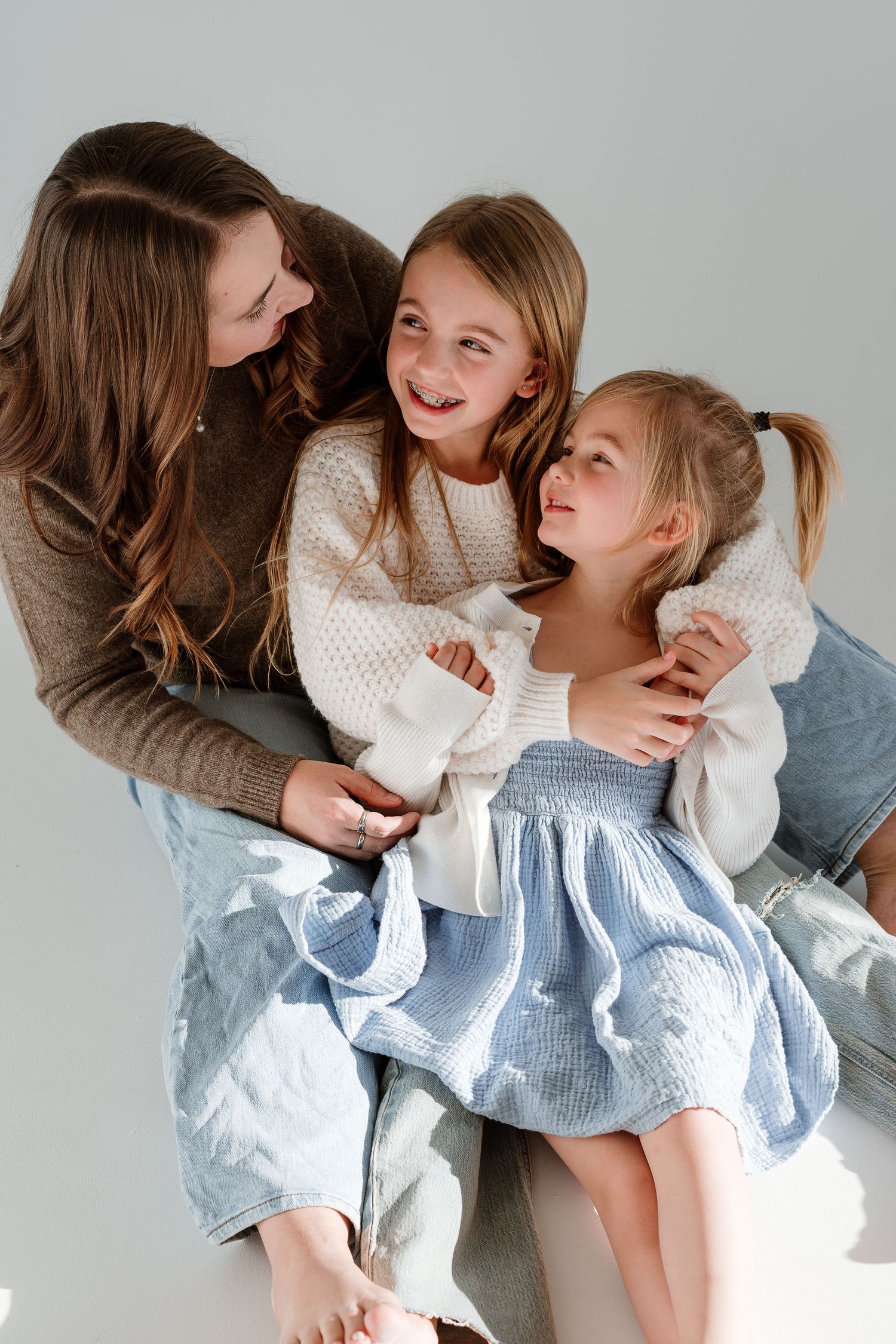 A series of four tender moments captured in a light and airy setting with soft white and blue clothing.