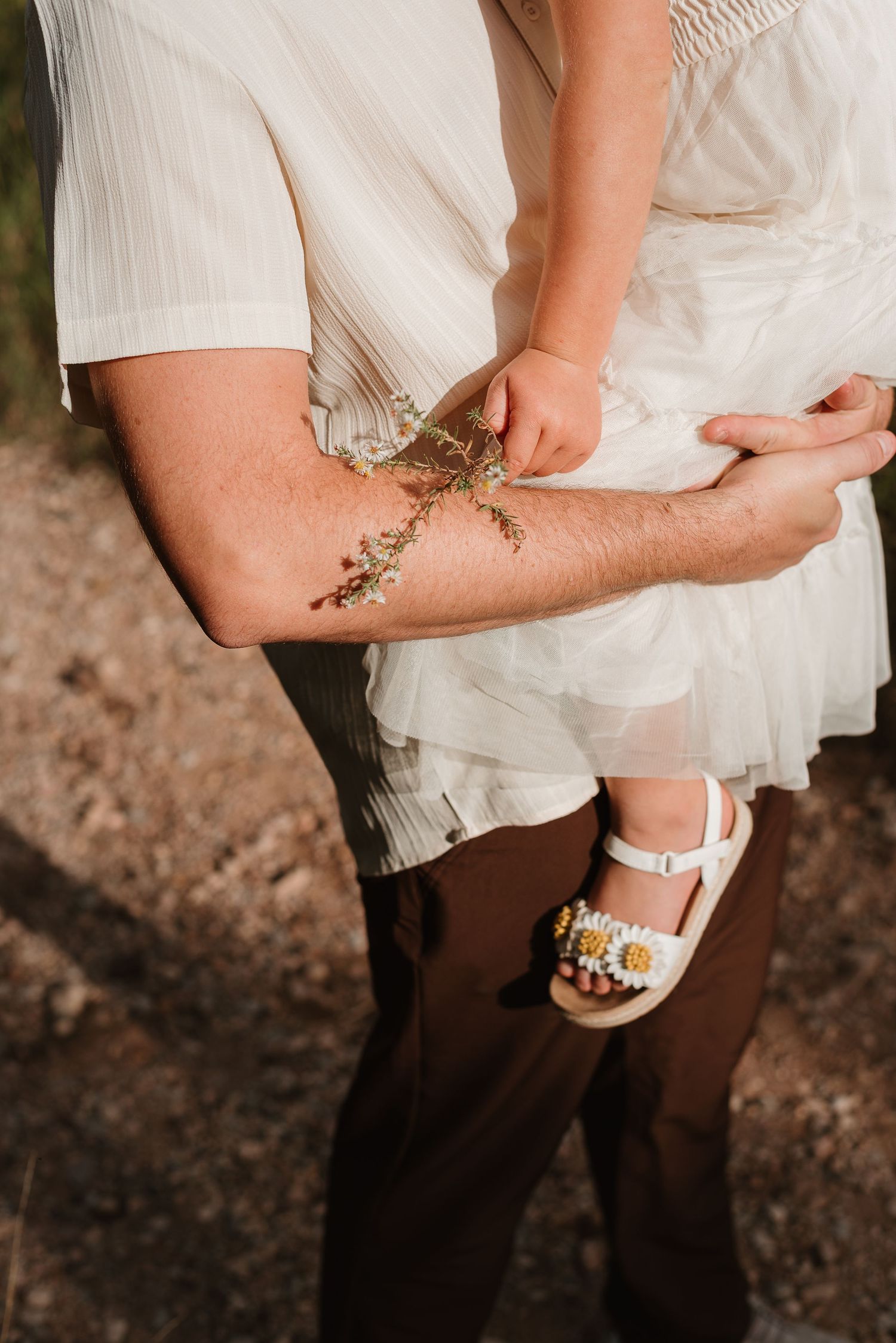 Close-up shot of a bride's garter decorated with small flowers and delicate details on her leg.