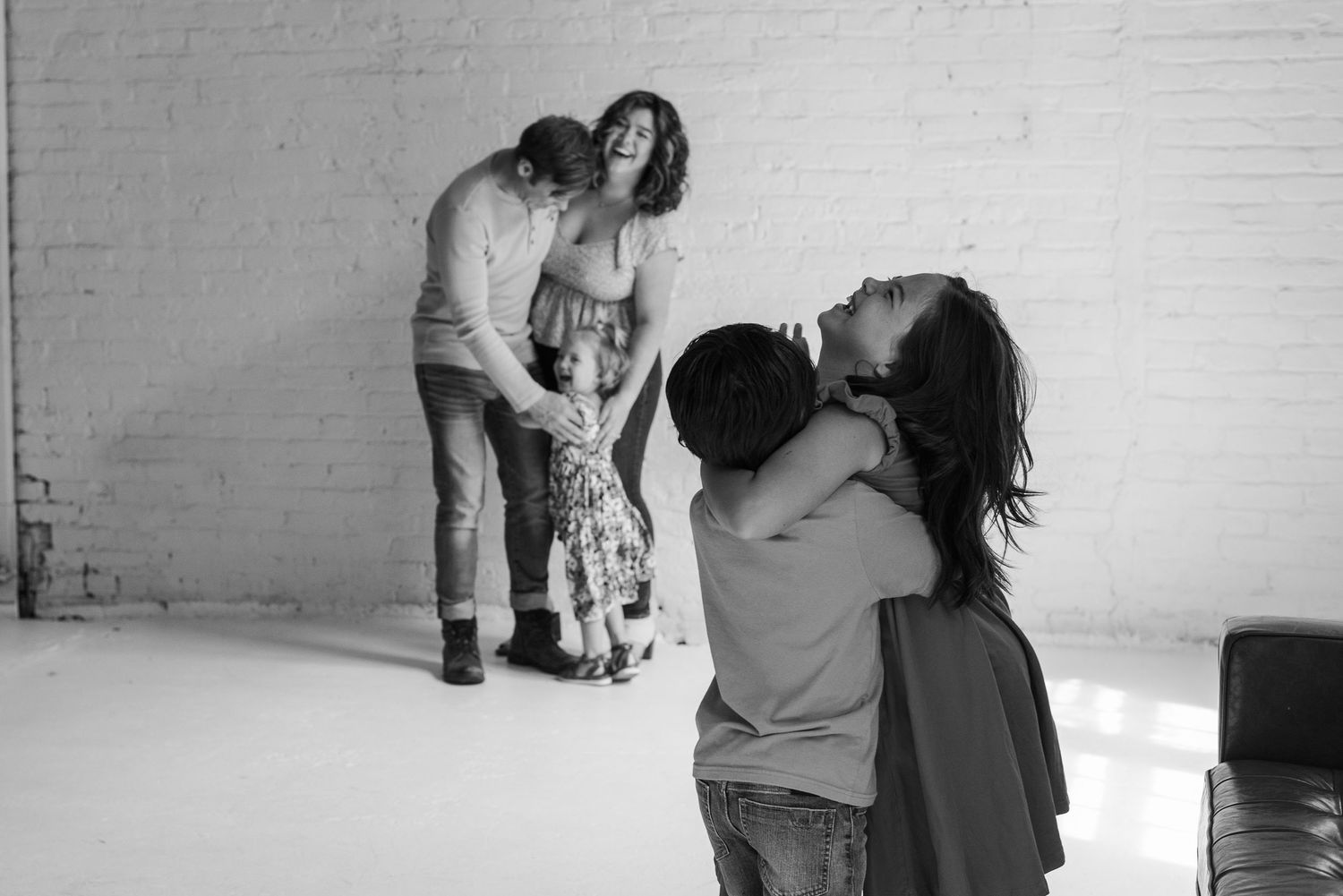 Black and white photos capturing intimate moments of affection against a white wall.