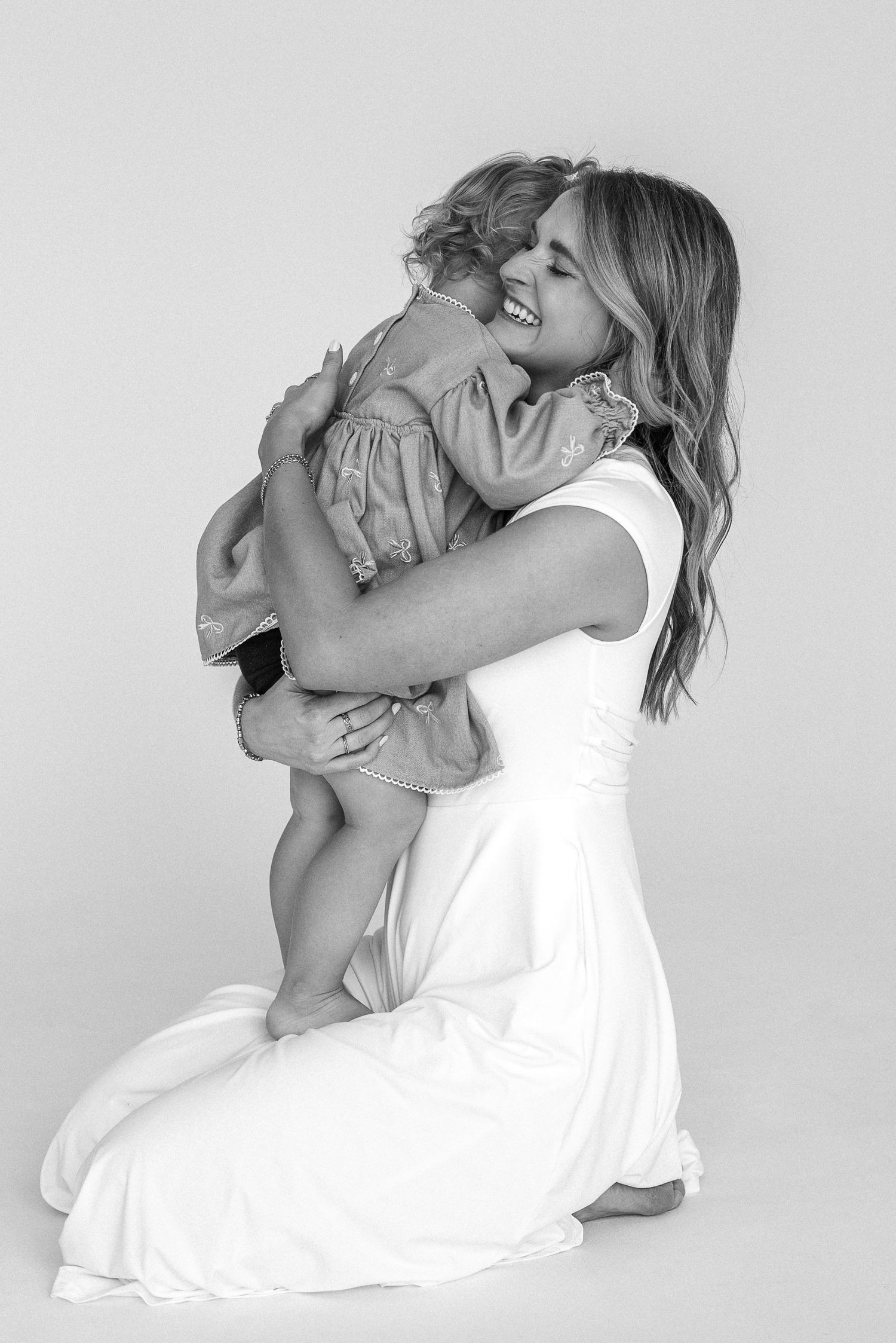 A series of black and white photos showing joyful moments between parent and child against a light background.