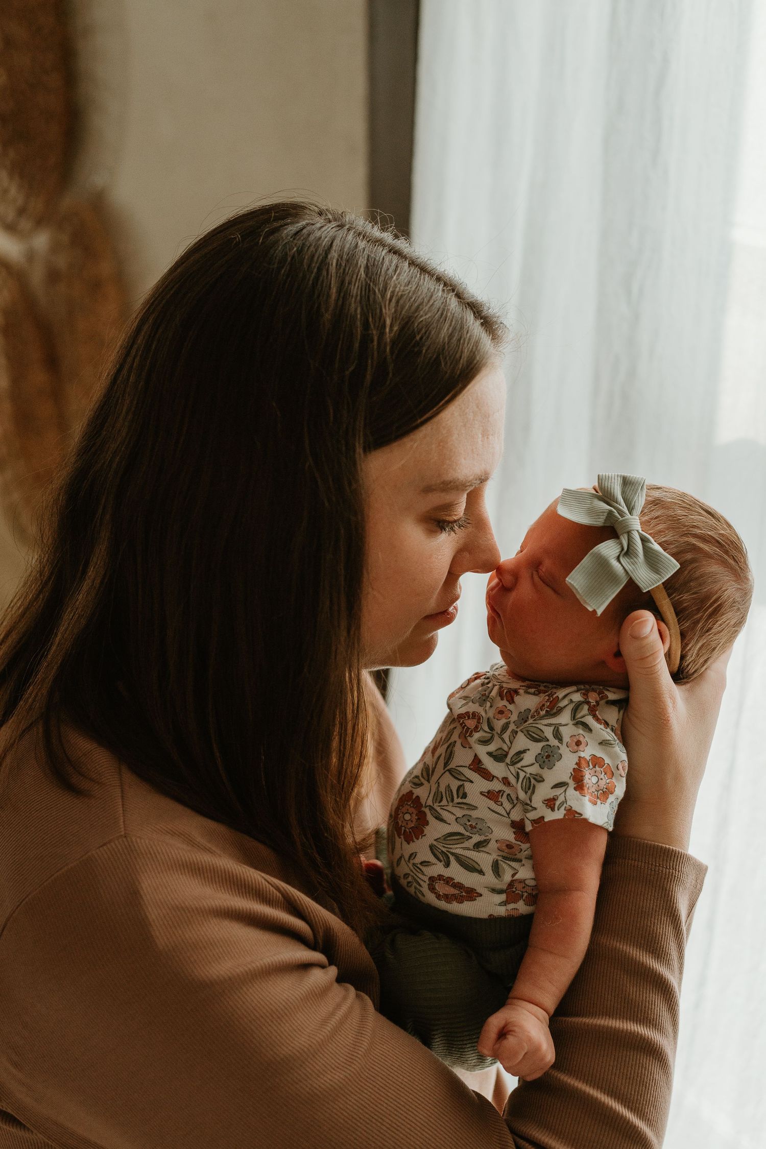 A series of tender moments between a mother and baby in warm, natural lighting against a neutral background.