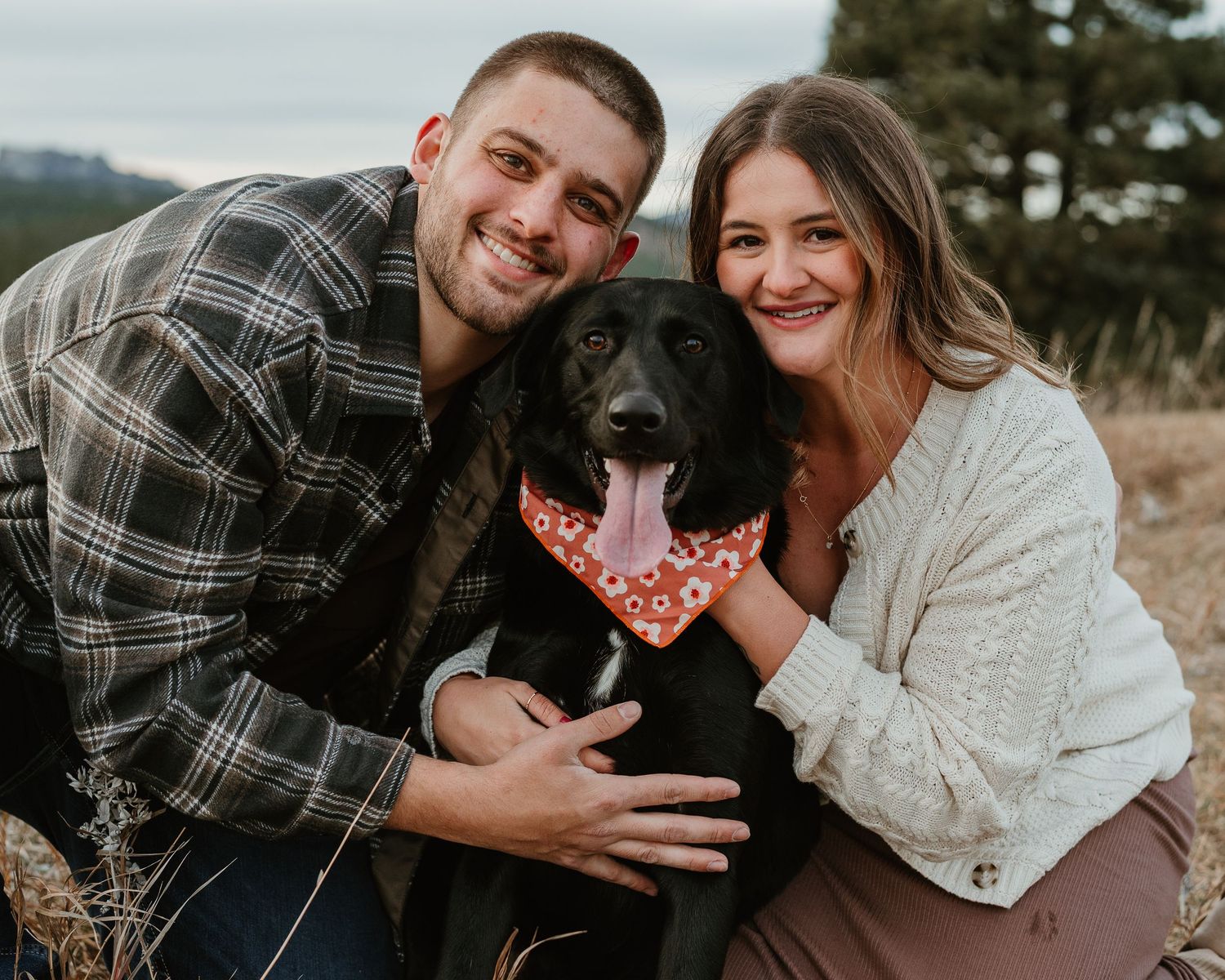 Couple in plaid and white sharing intimate moments in a rustic outdoor setting during a photoshoot.