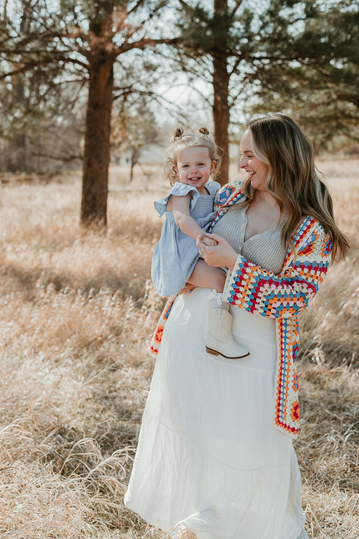 Candid playtime captured in a natural setting with matching crochet cardigans.
