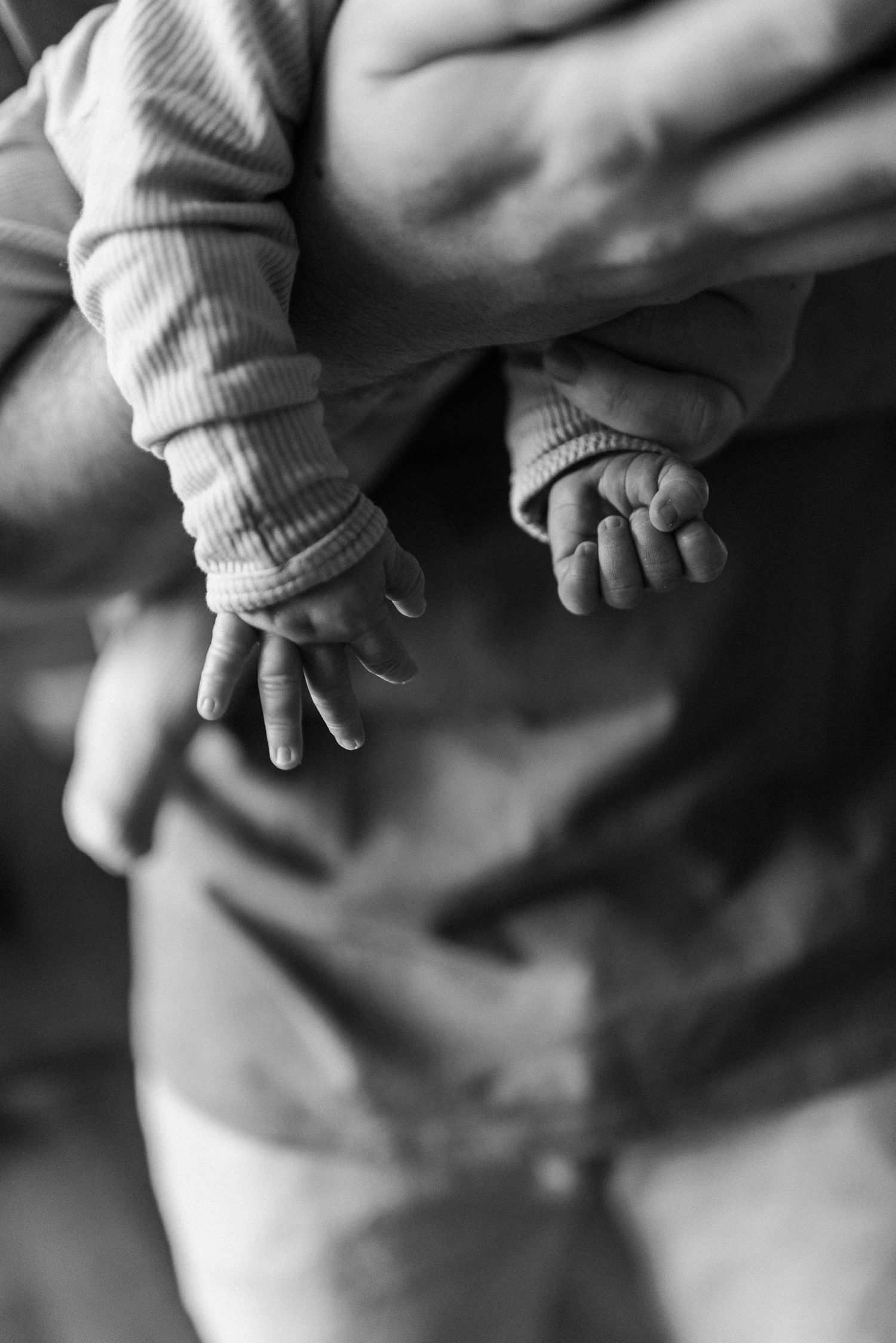 A black and white close-up photo sequence showing a baby's tiny hand in soft focus.