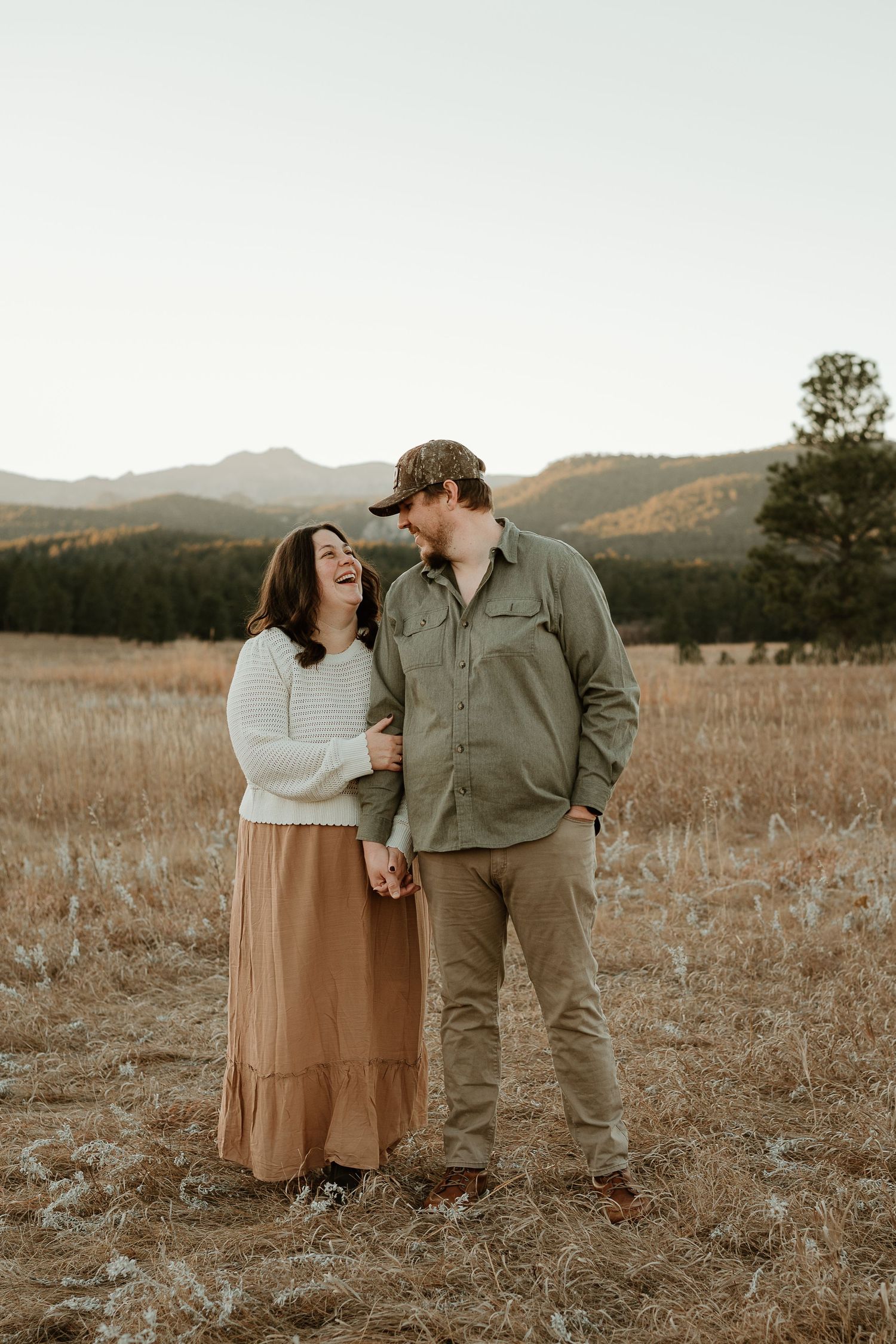 Intimate couple portrait session in a golden mountain meadow during sunset.