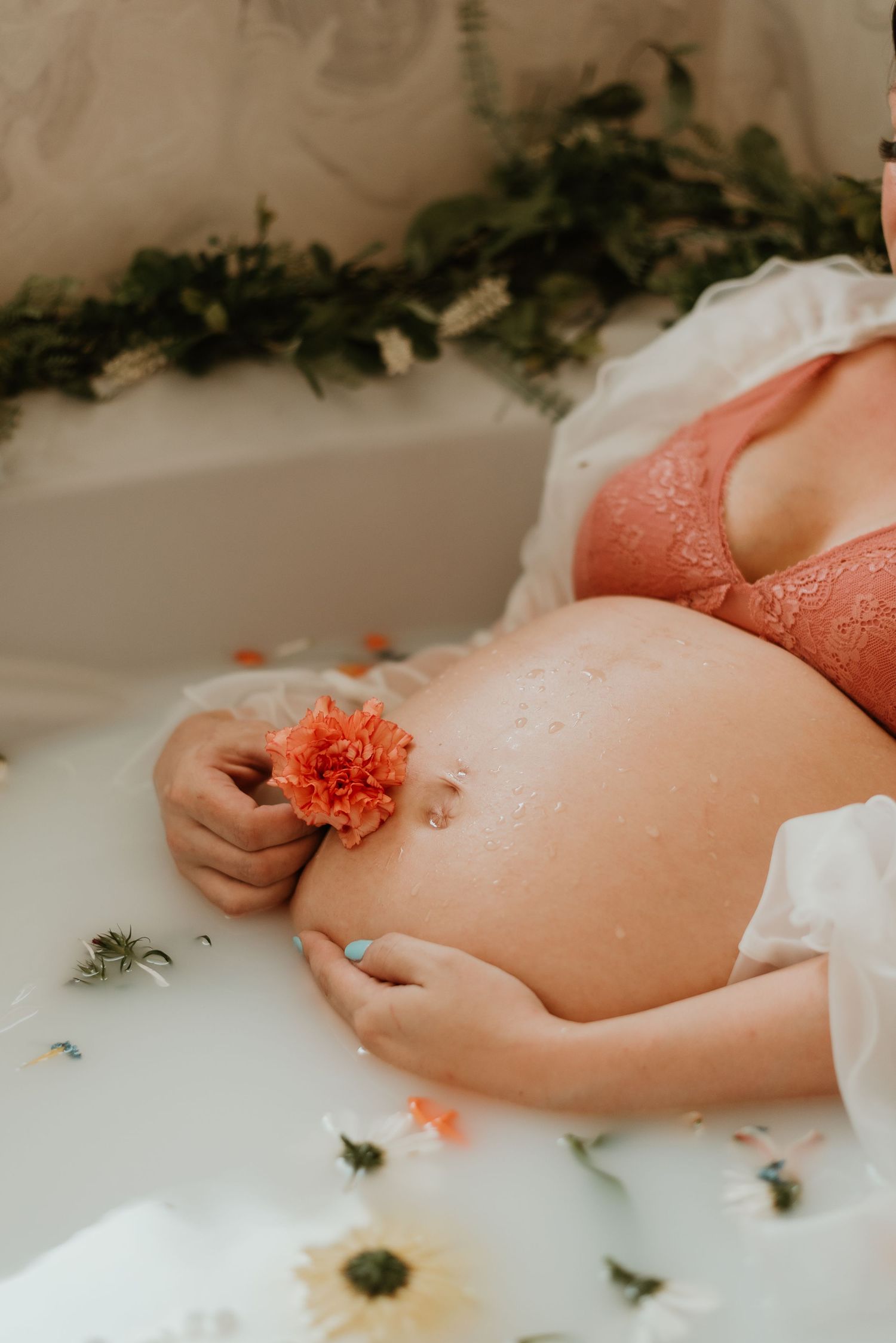 Floral milk bath photography featuring coral and yellow blooms.
