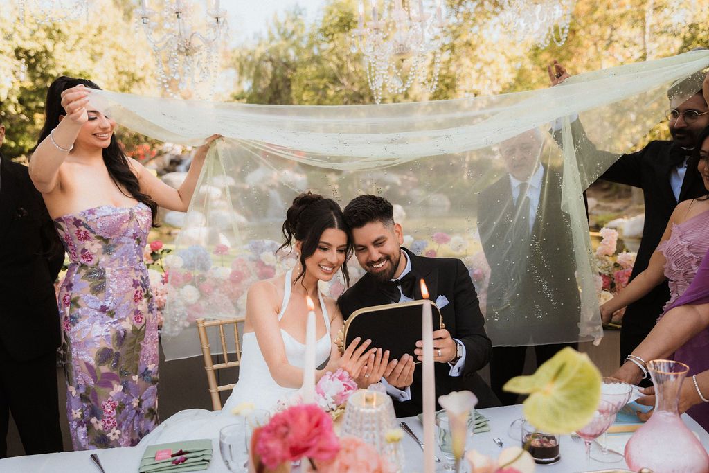 Cinematic outdoor wedding at Coyote Hills. A whimsical moment under a flowing veil with bridesmaids in elegant floral patterns