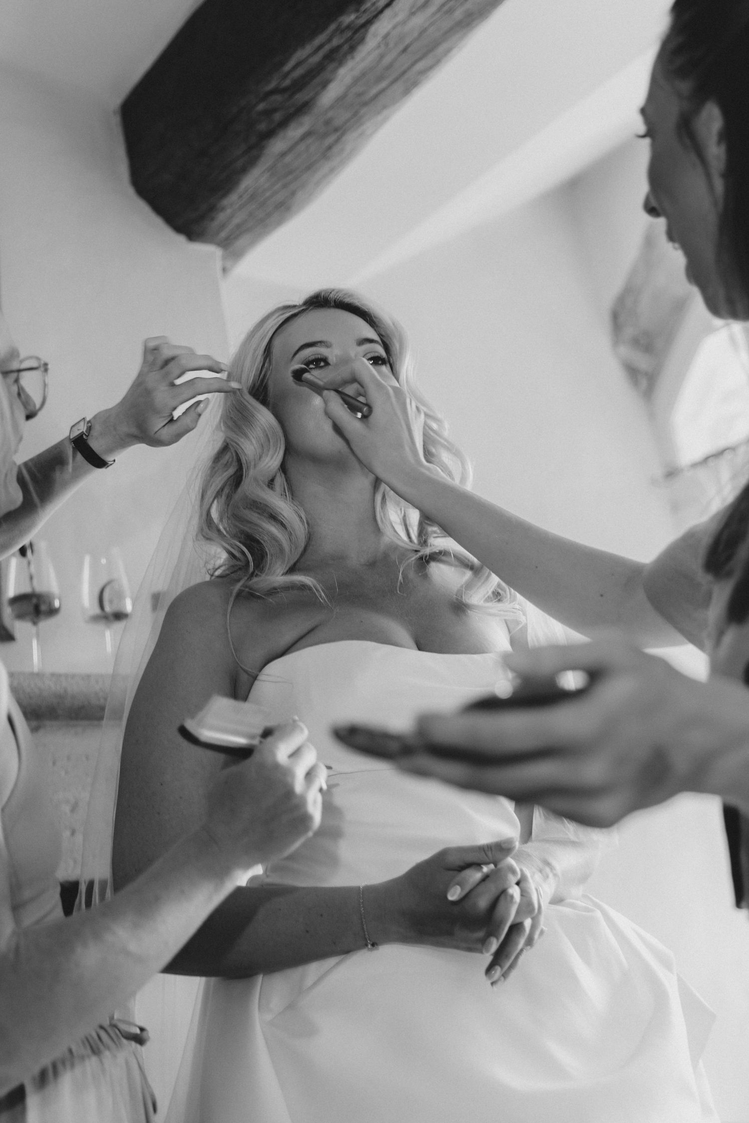Black and white photo sequence showing someone being assisted with putting on a wedding dress.